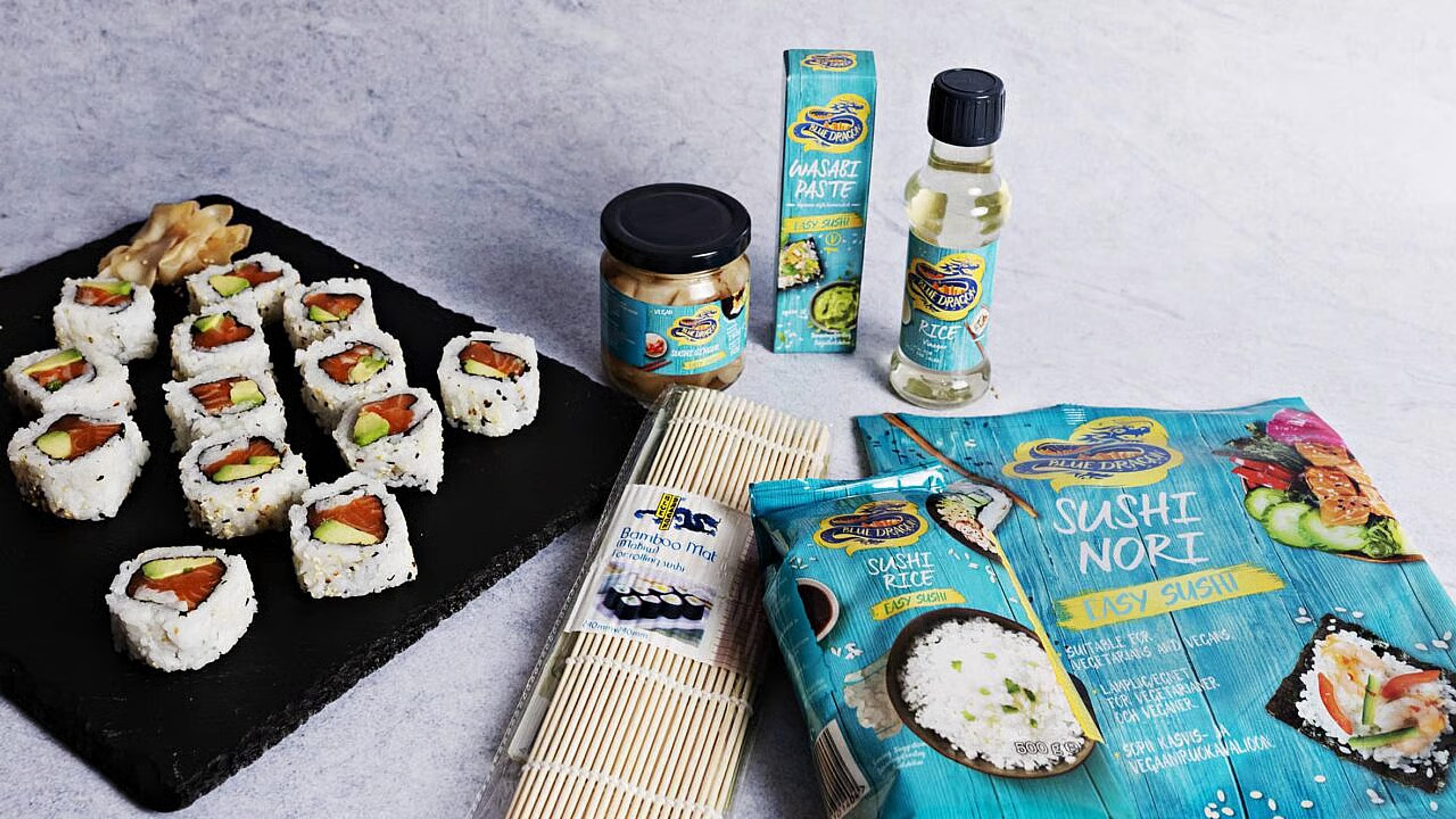 Sushi servert på steinfat med ingredienser ved siden av.
