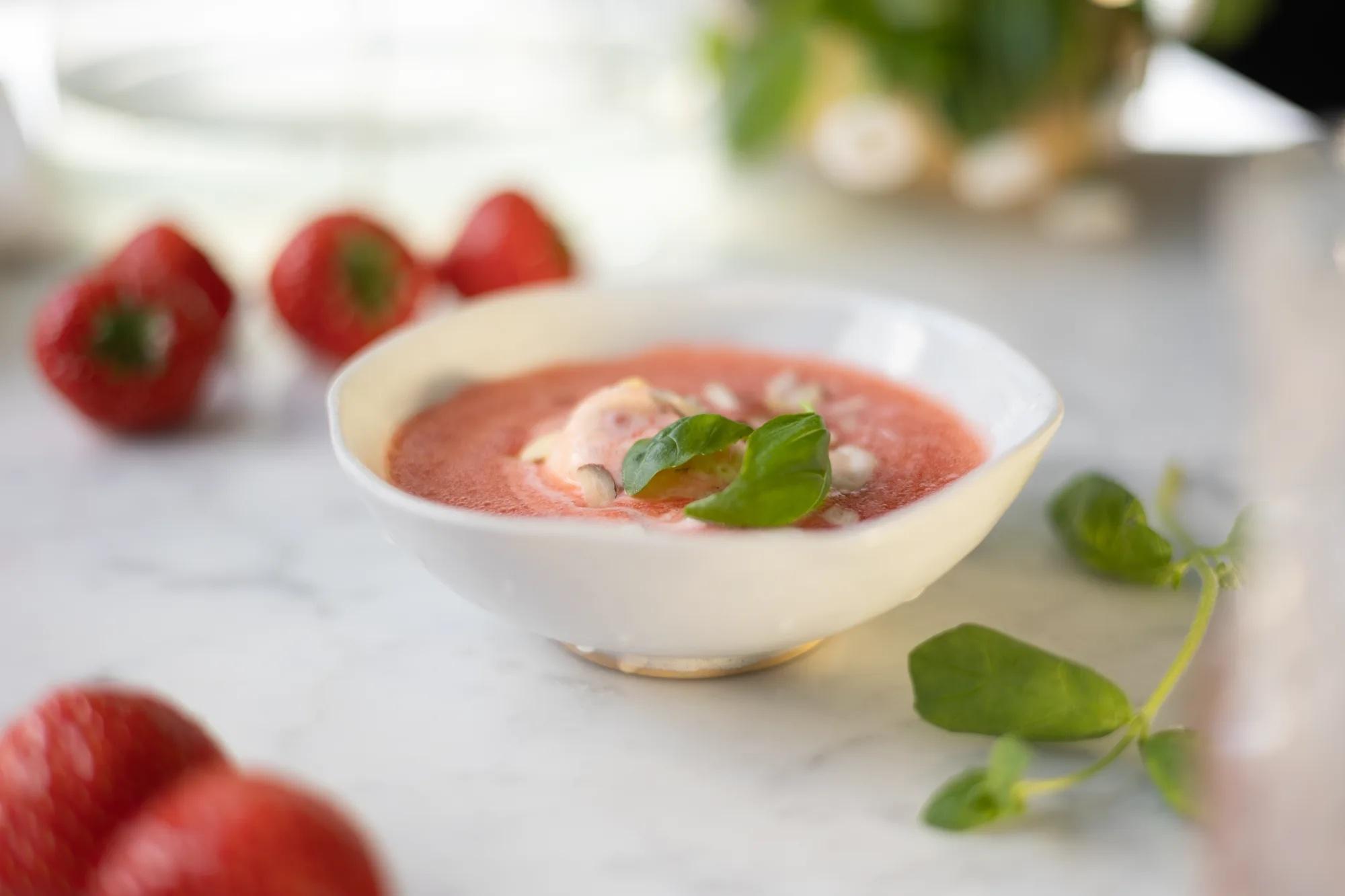 jordbærsuppe i skål med basilikumblad på