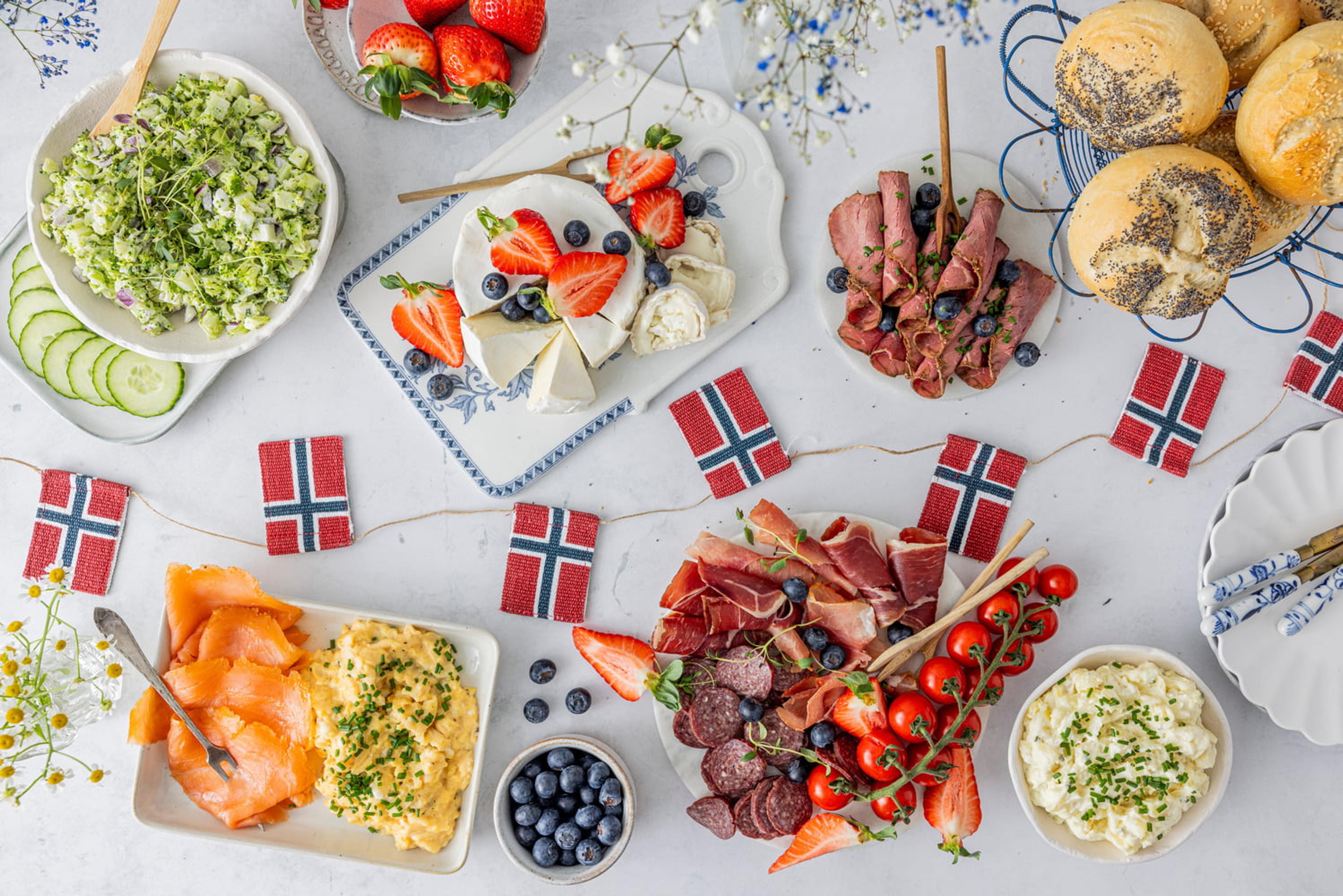 Norsk koldtbord med salat, brie, roastbiff, rundstykker, laks og eggerøre, potetsalat, spekemat og norske vimpelflagg.