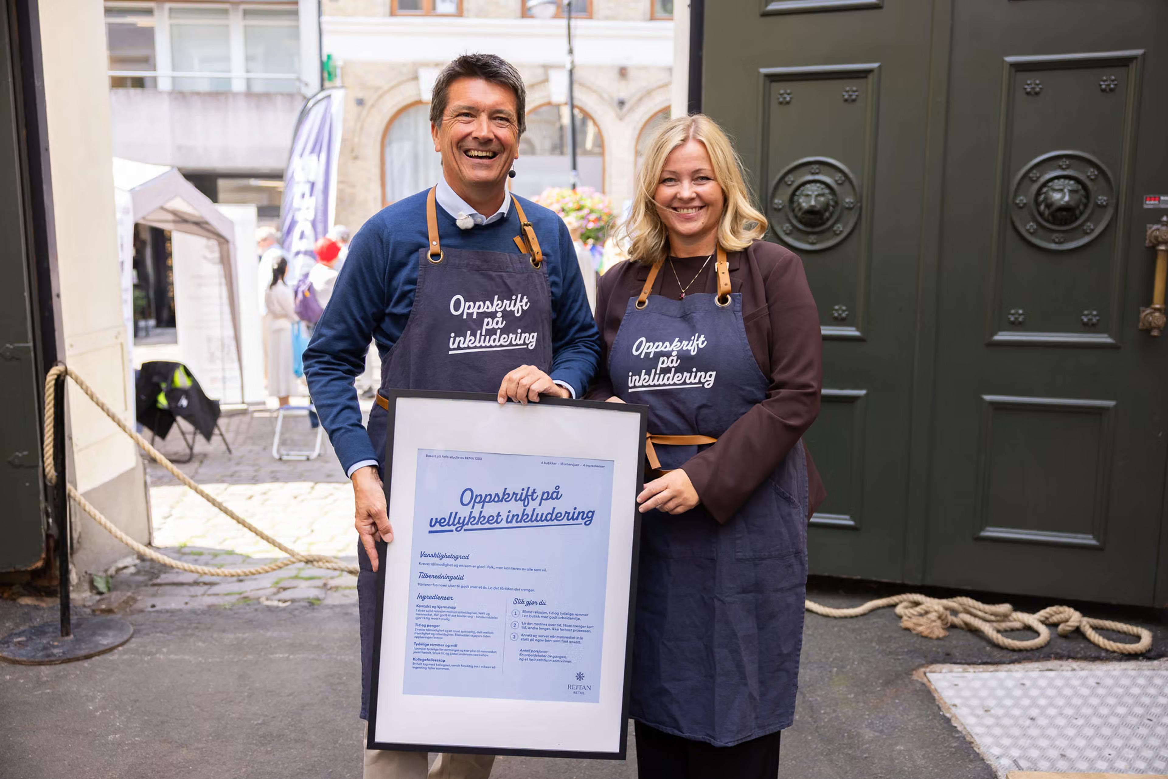 Bilde av Ole Robert Reitan, administrerende direktør i Reitan Retail, og arbeids- og inkluderingsminister Kjersti Stenseng under overrekkelsen av rapporten på Arendalsuka 2026. Oppskriften på vellykket inkludering fikk ministeren med seg hjem.