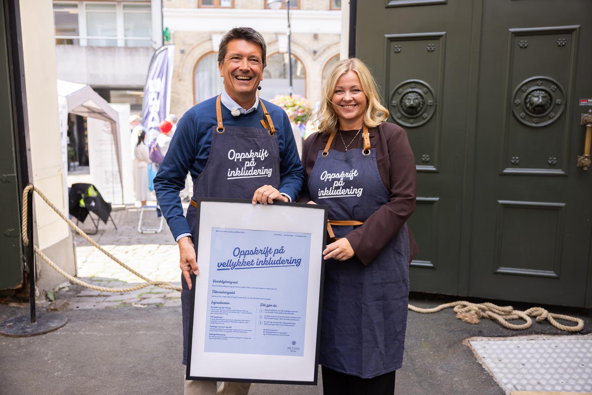 Bilde av Ole Robert Reitan, administrerende direktør i Reitan Retail, og arbeids- og inkluderingsminister Kjersti Stenseng under overrekkelsen av rapporten på Arendalsuka 2026. Oppskriften på vellykket inkludering fikk ministeren med seg hjem.