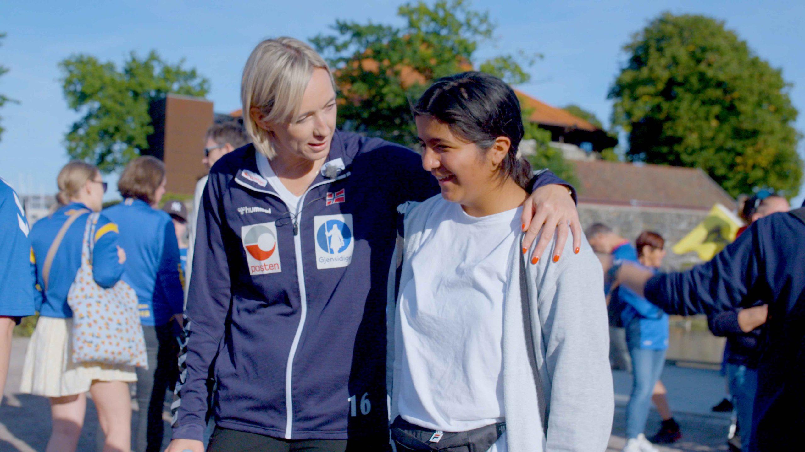 En deltaker og en håndballprofil står sammen utendørs under et arrangement i regi av REMA 1000 Hjerteligaen.