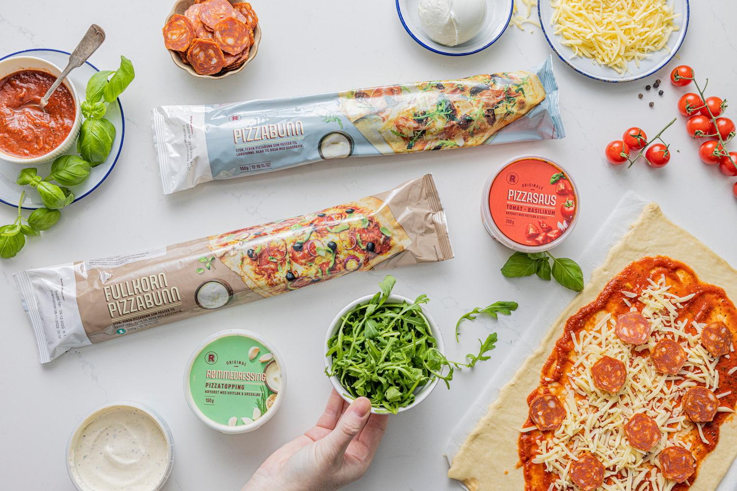 Ingredienser til hjemmelaget pizza med pizzabunn, saus, ost og ruccola.