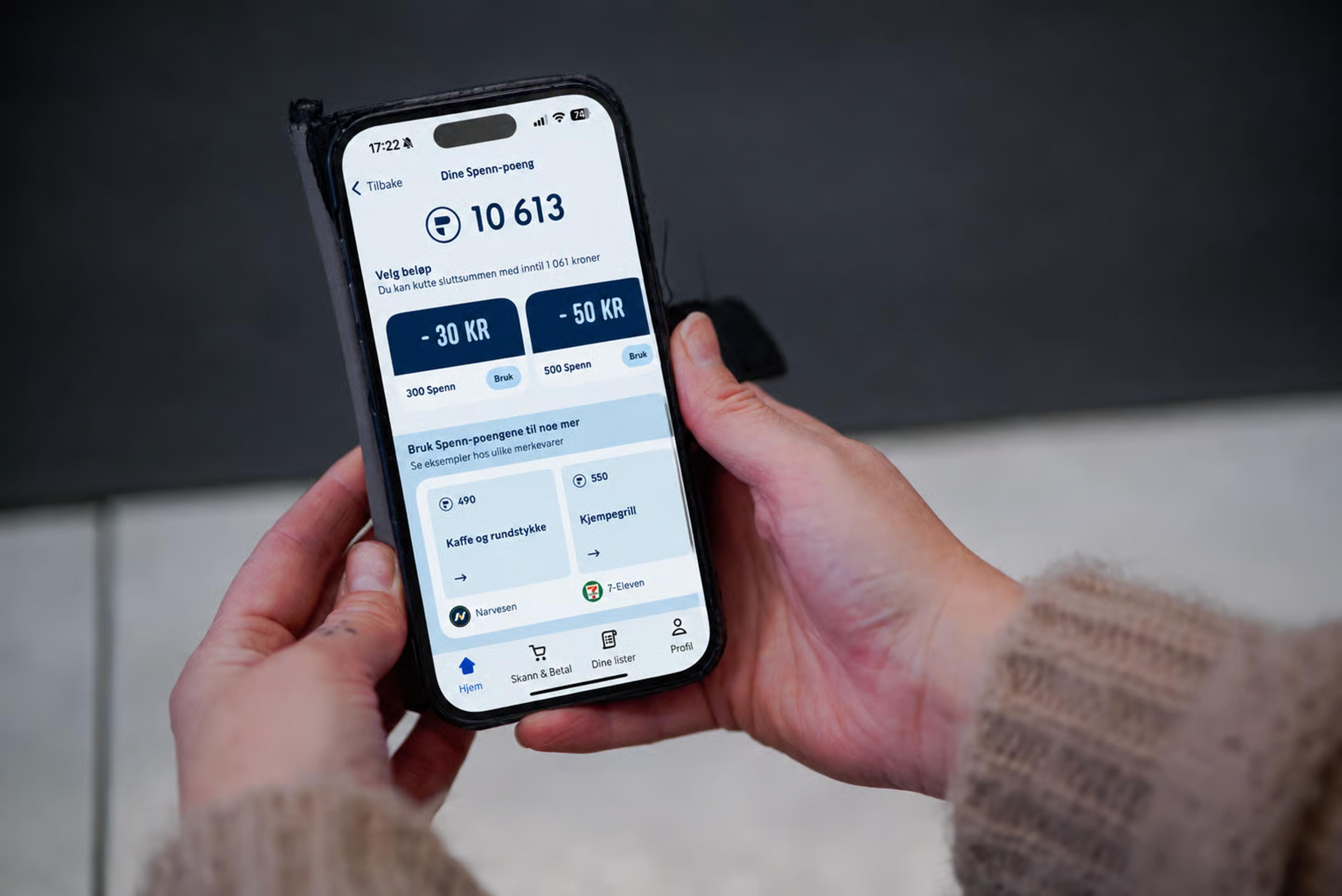 Person som holder smarttelefon med Rema-appen åpen