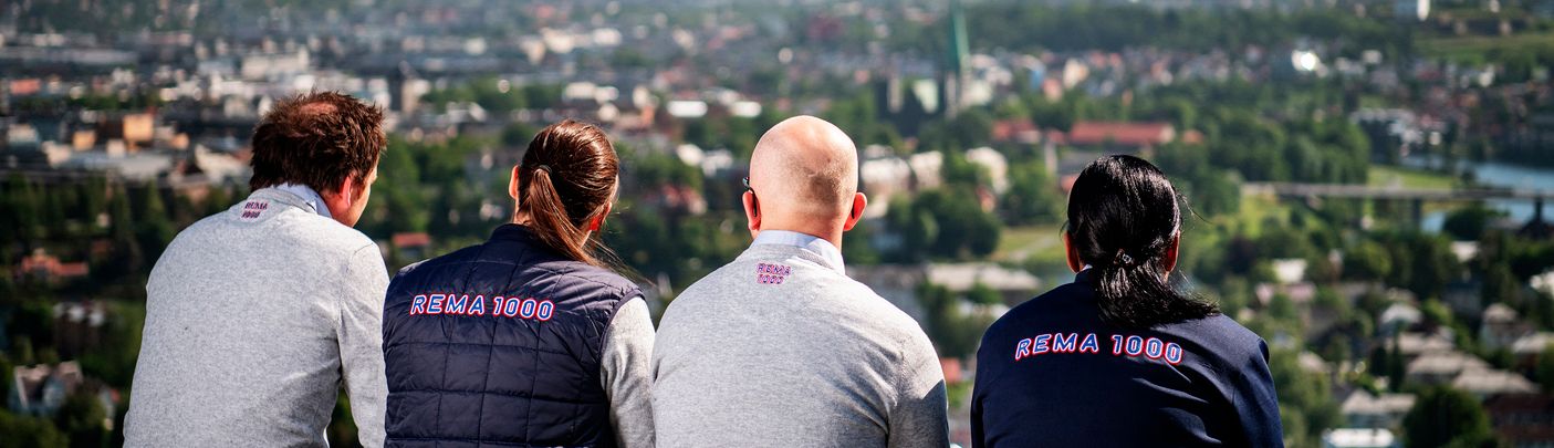 Fire rema ansatte ser ut over en fin utsikt over en by