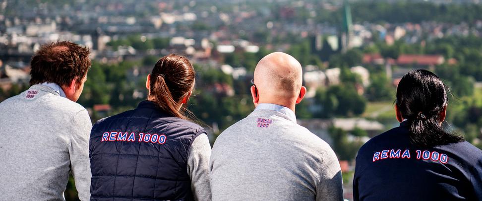 Fire rema ansatte ser ut over en fin utsikt over en by