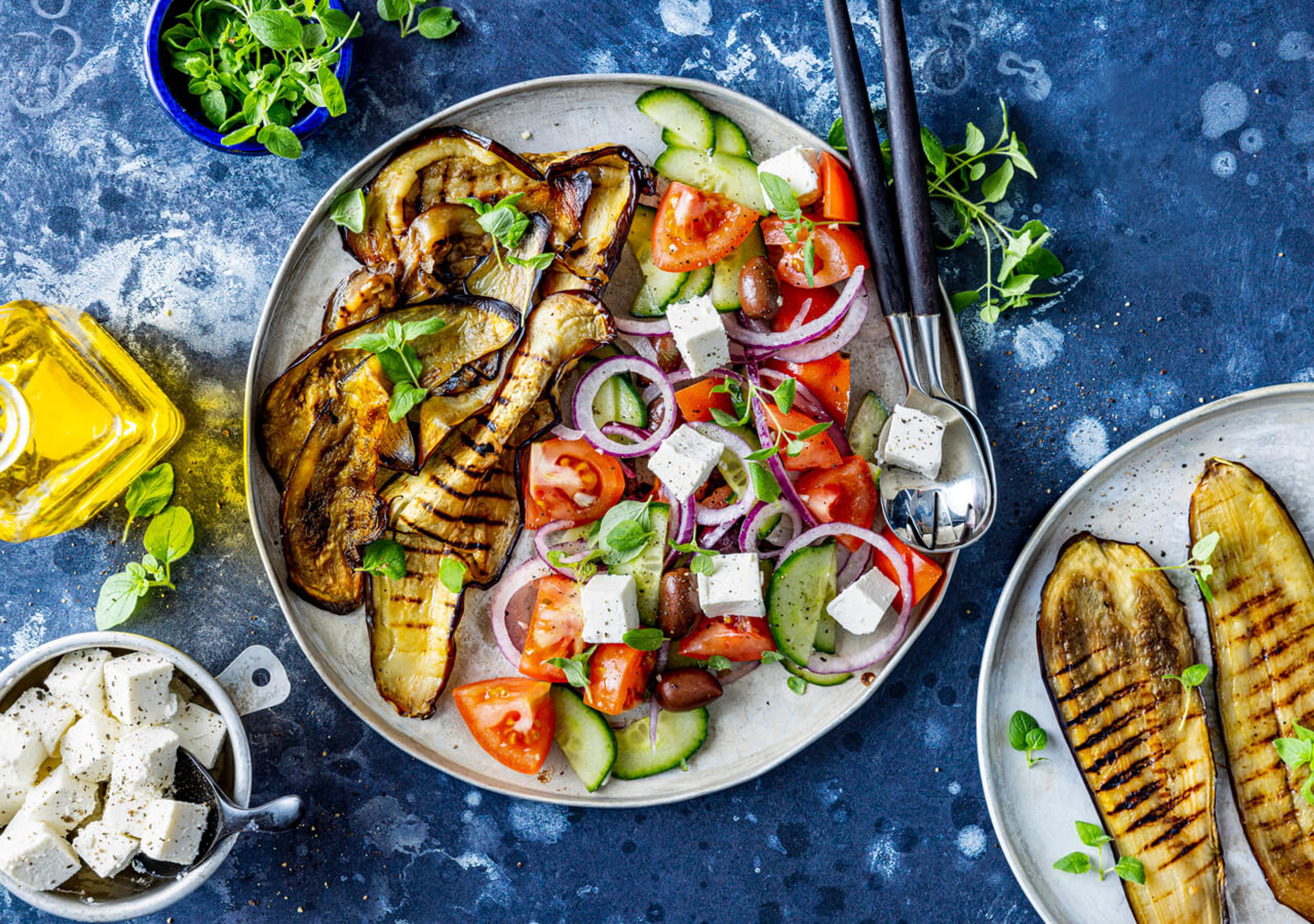 Gresk salat med grillet aubergine, tomat, agurk, rødløk, oliven og fetaost i en stor skål