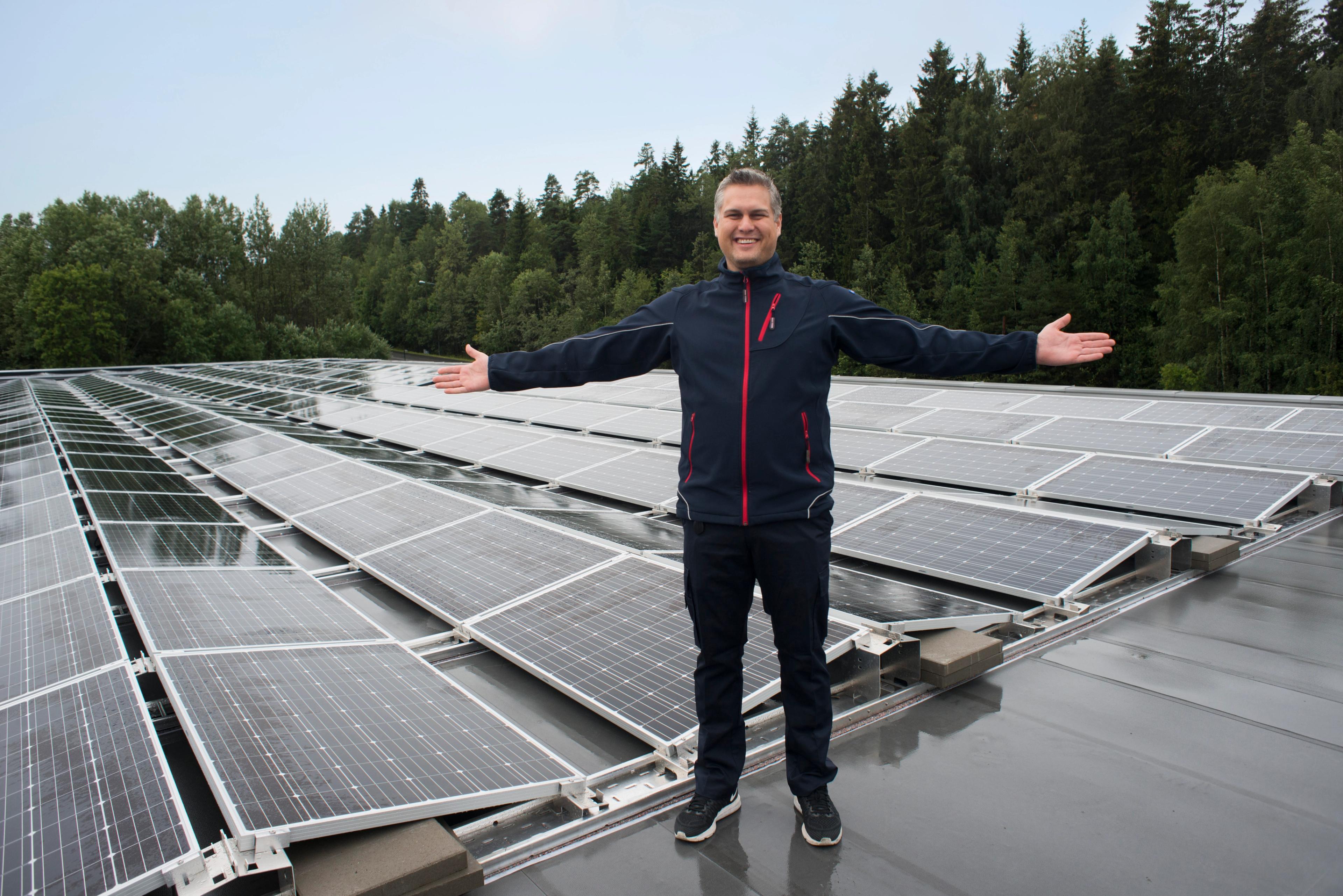 Mann som står ved solcelle paneler