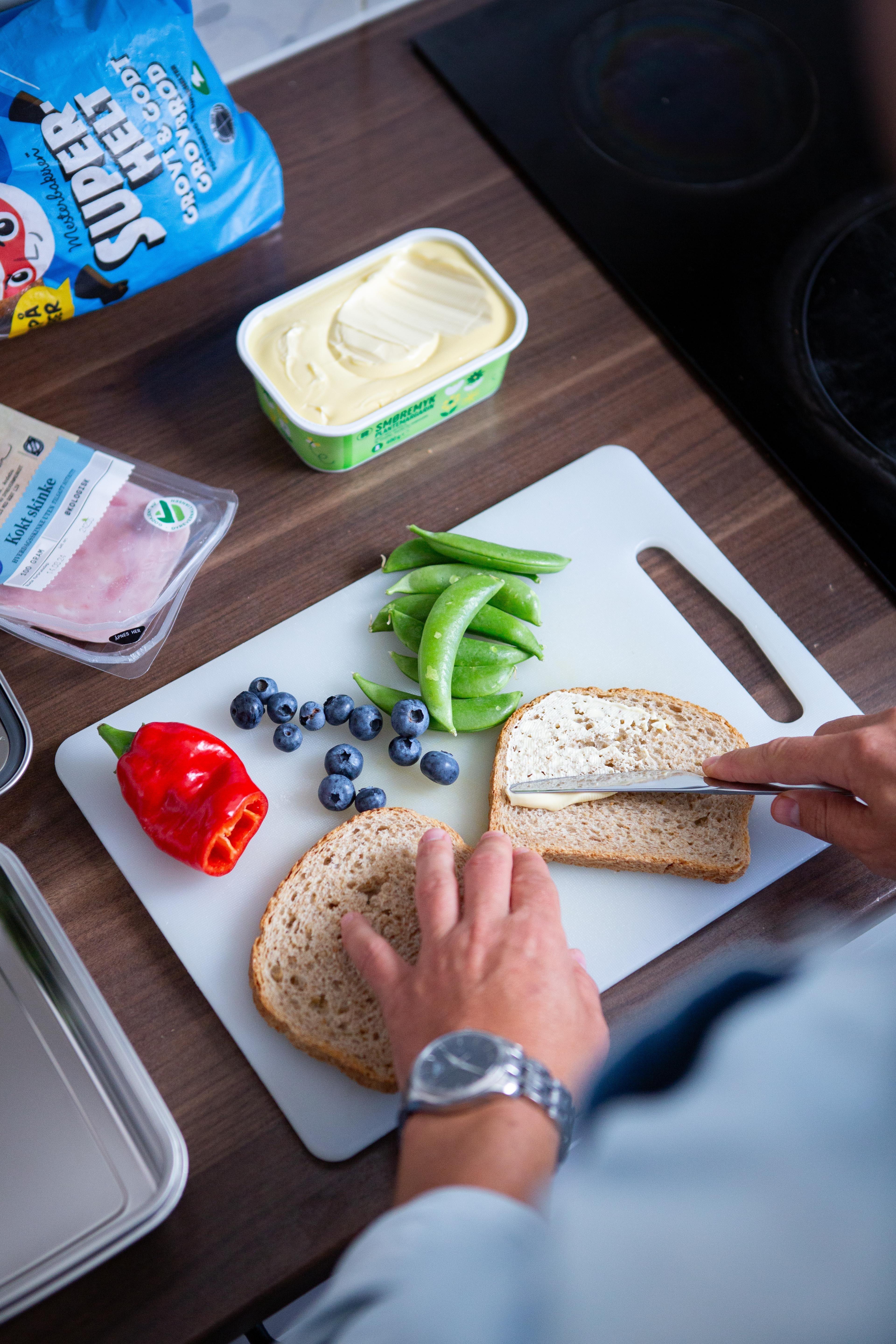 Bilde av hender som smører brødskiver
