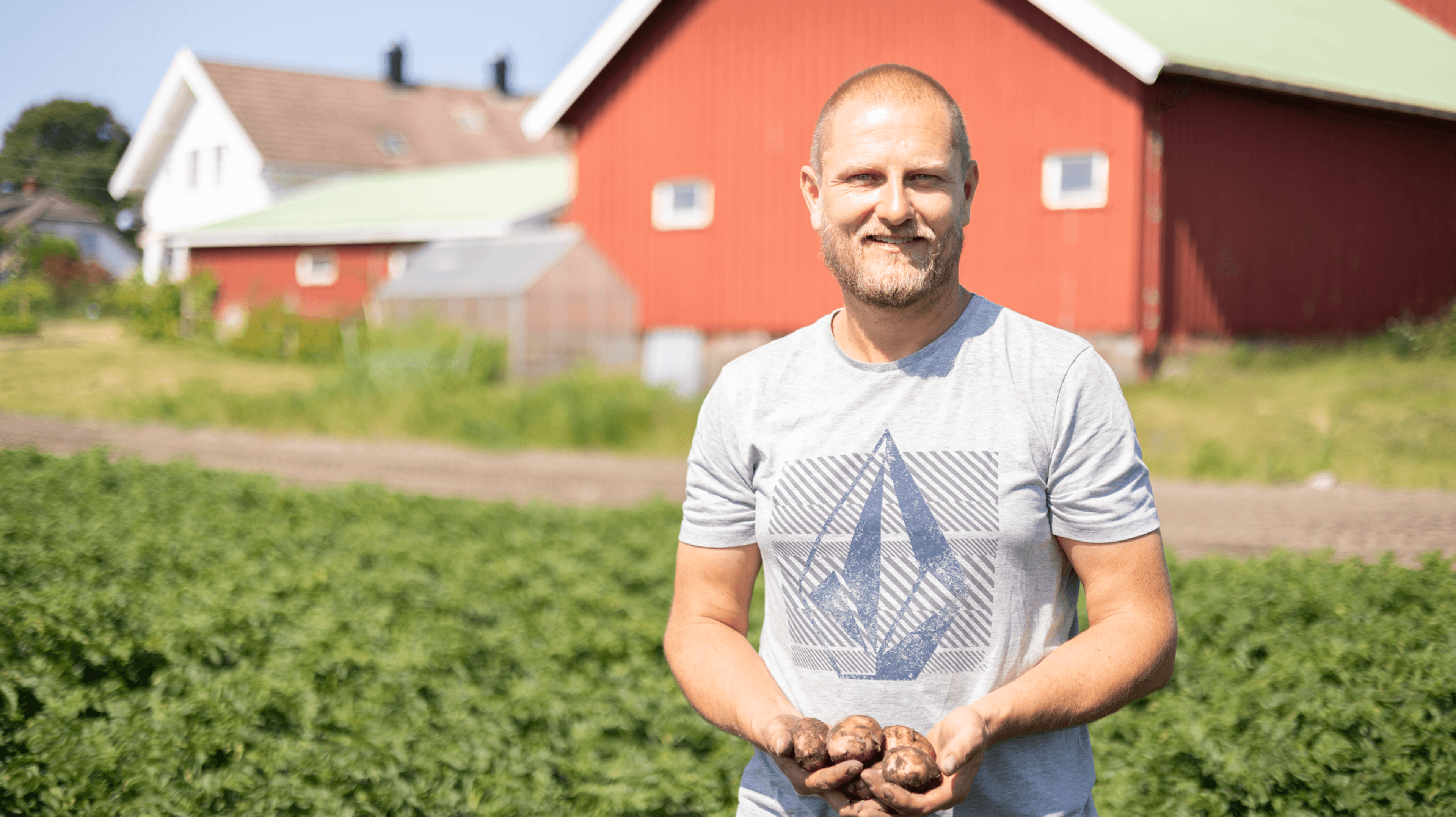 norske bonden fredrik bakke står med poteter i hånda og smiler til kamera