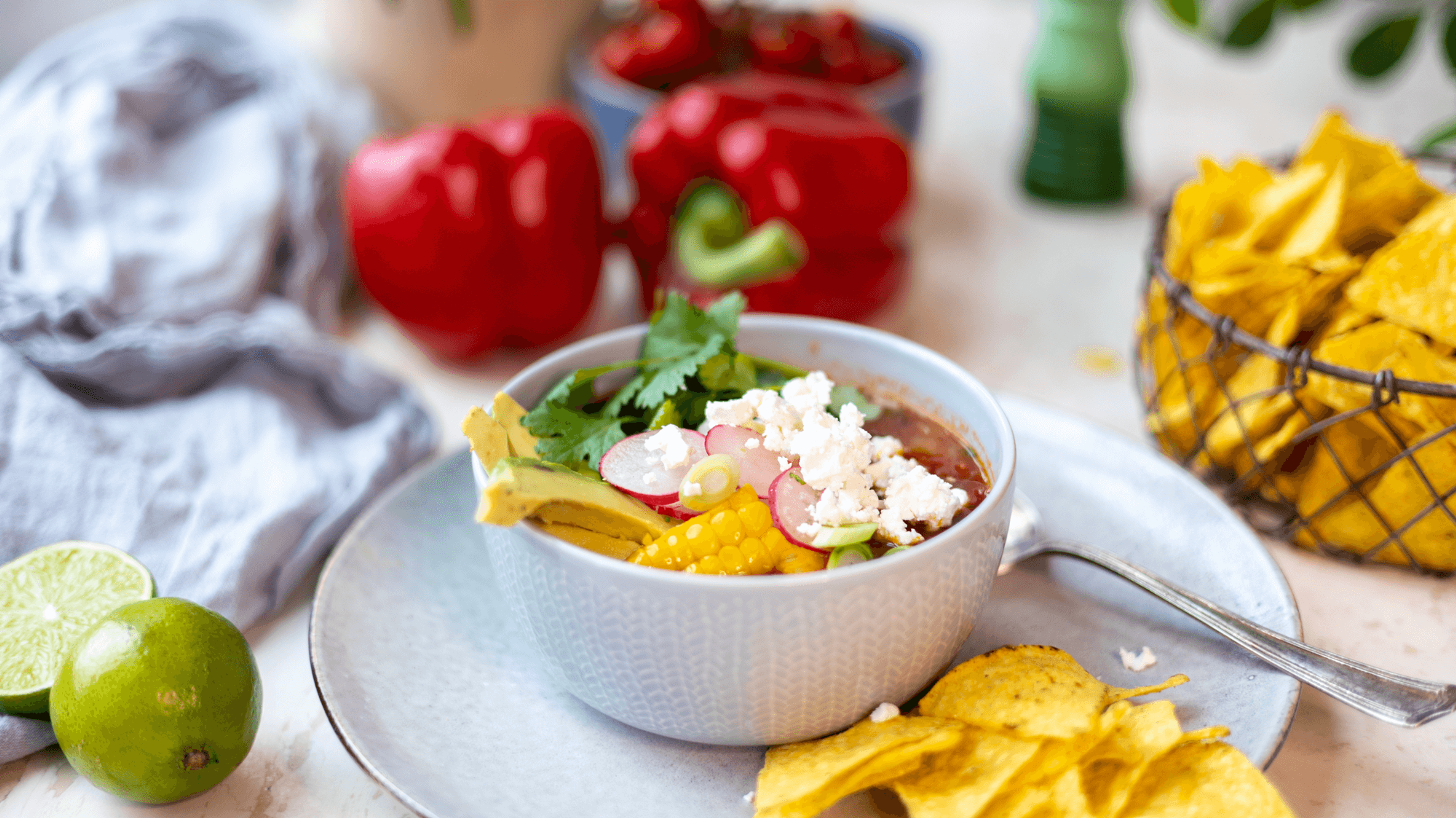 tacosuppe i en skål på et bord omringet av ingredienser