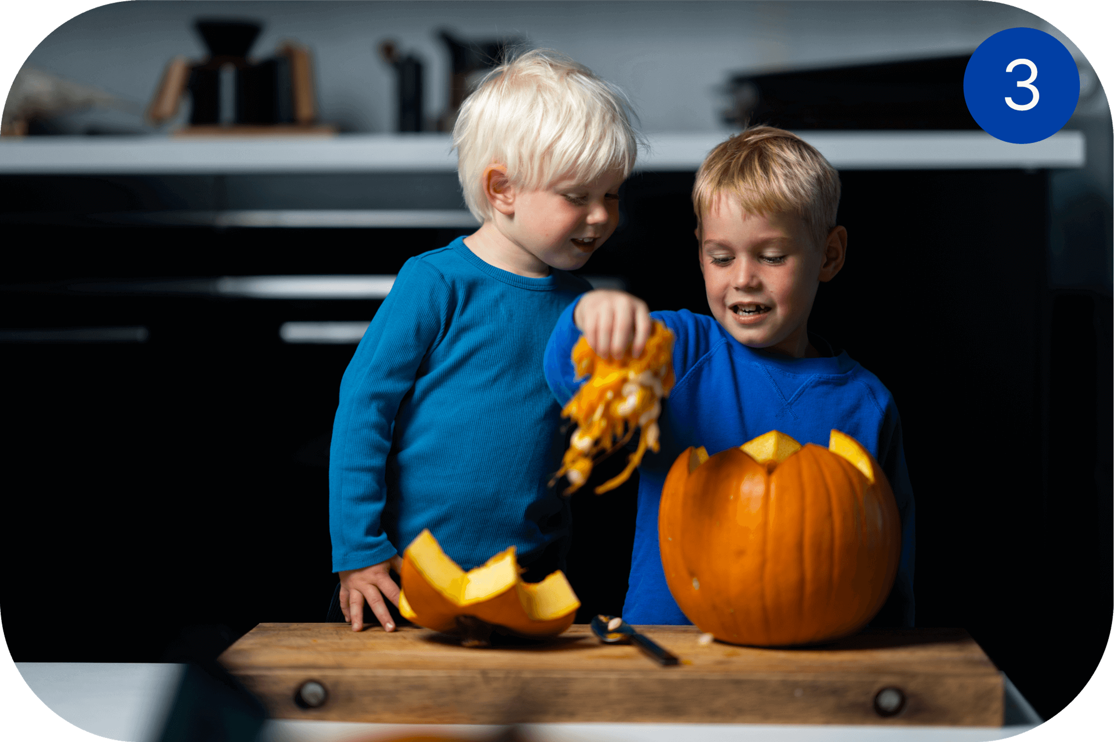 To barn tømmer et gresskar for frø og innmat før Halloween-utskjæring.