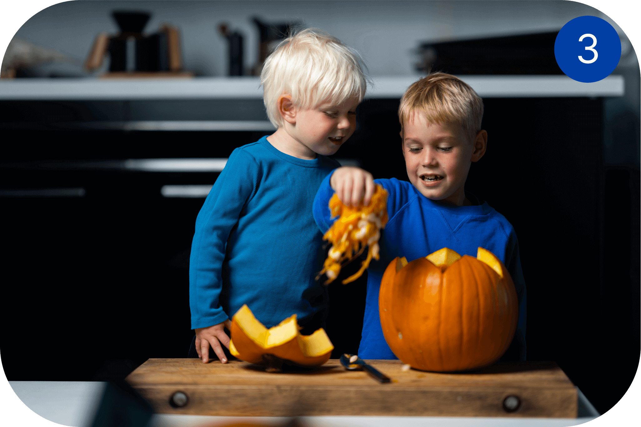 To barn tømmer et gresskar for frø og innmat før Halloween-utskjæring.