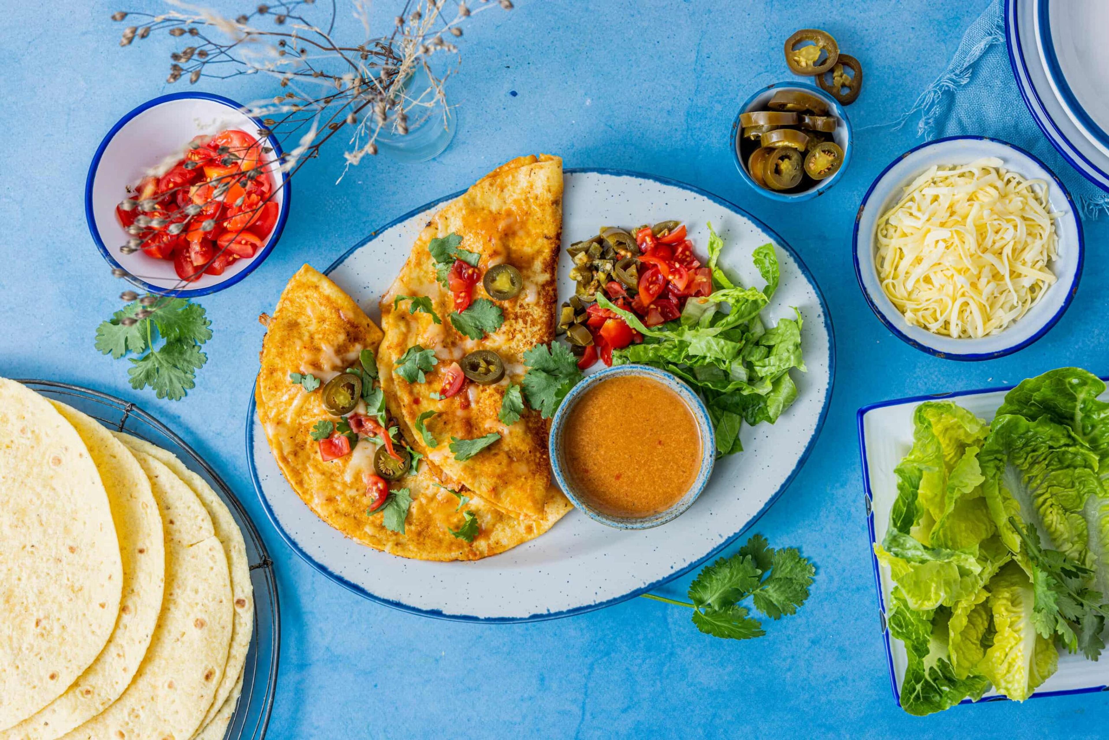 Sprø tacotortillas fylt med saftig kylling og ost, servert med salat, koriander, tomater og jalapeños. Perfekt for familie eller gjester