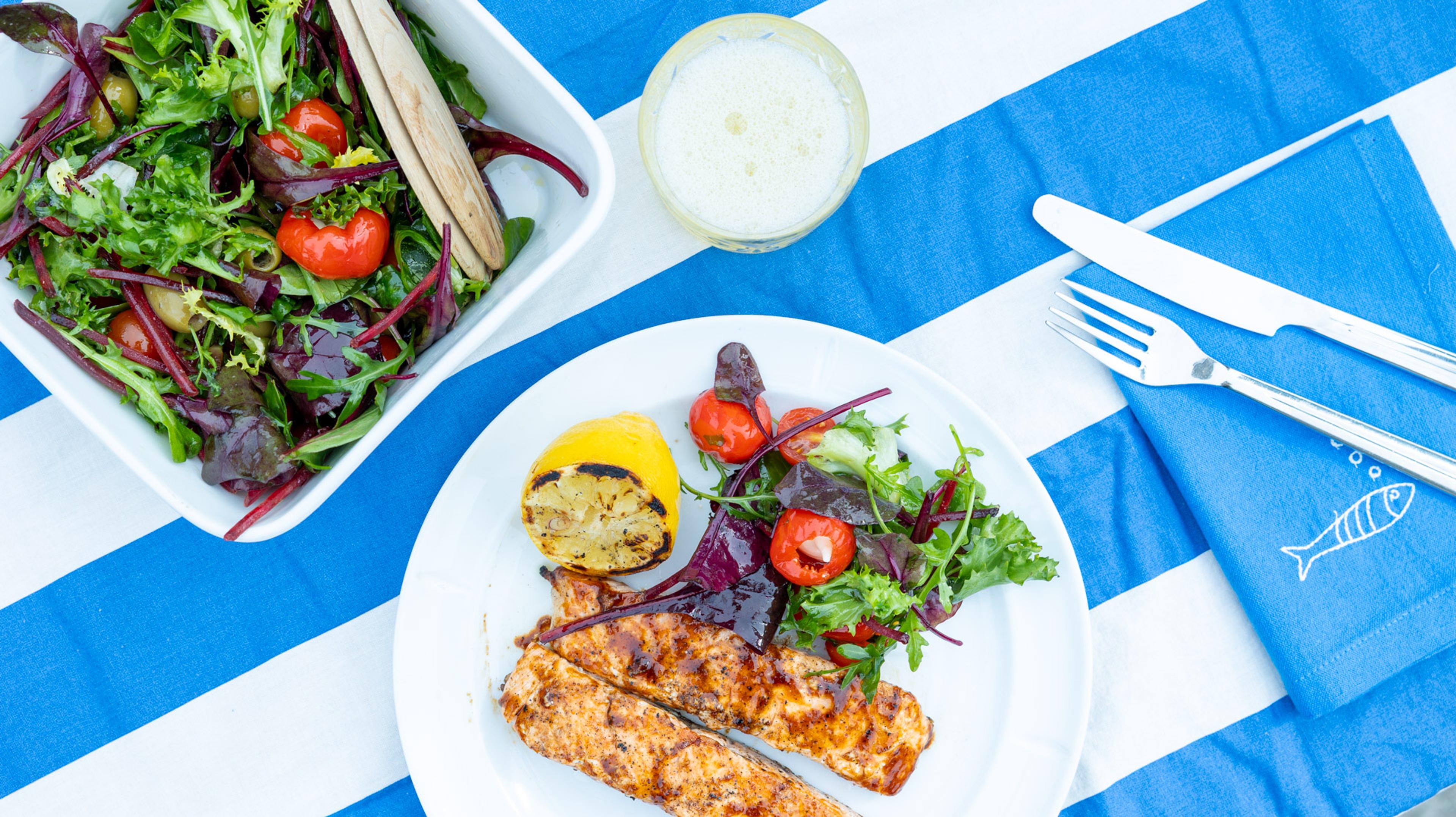 glacet laks med frisk salat til står på et bord