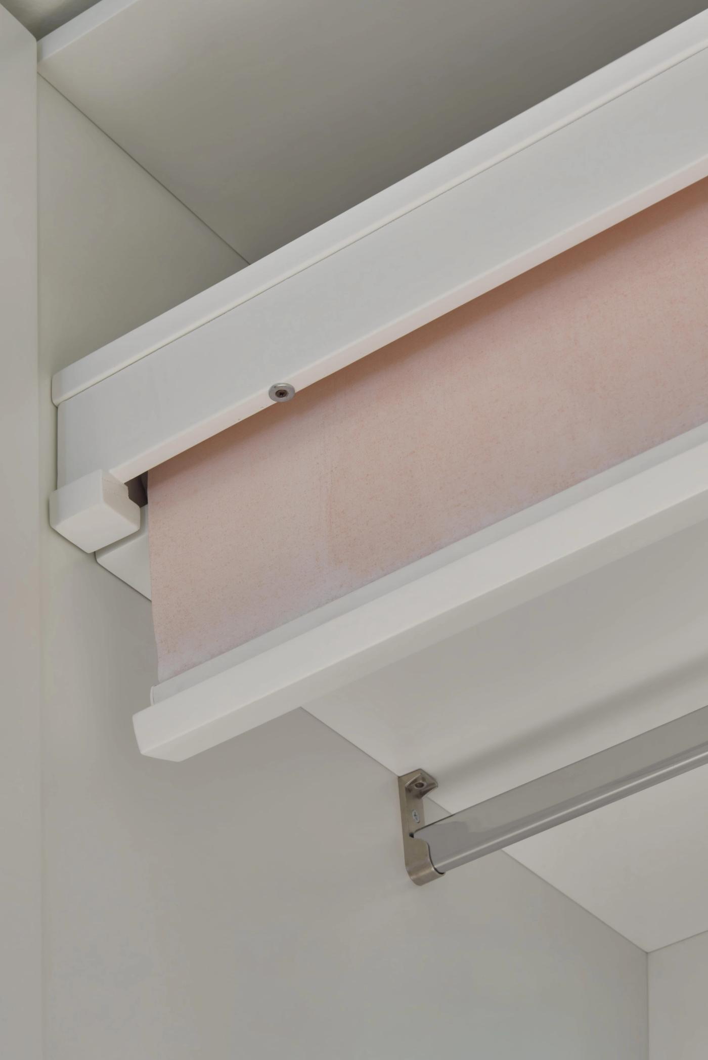 Serramenti in legno bianco con tenda a rullo rosa, dettaglio di qualità artigianale Loreti e Sibilla.