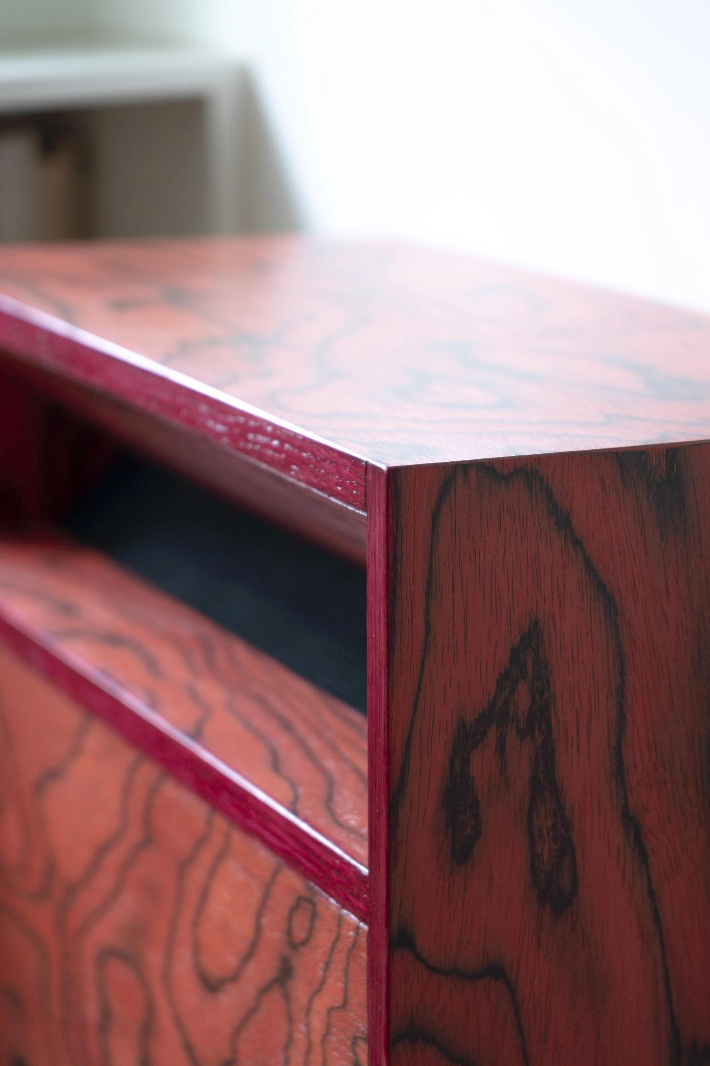 Dettaglio di mobile in legno massello rosso con finiture artigianali realizzato da falegnameria d'autore.