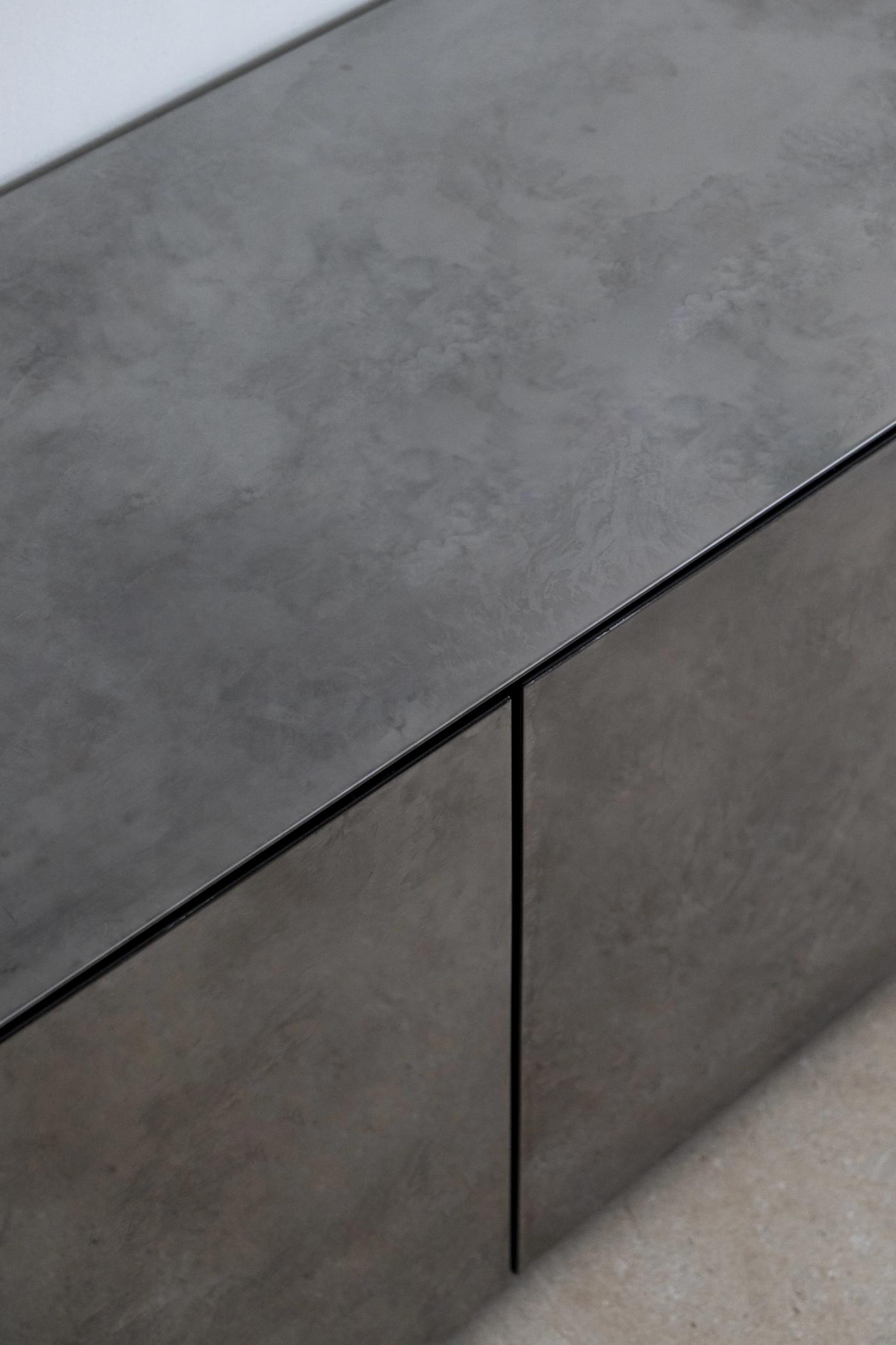 Arredamento su misura in cemento e legno con maniglie nere minimal, realizzato da Loreti e Sibilla.