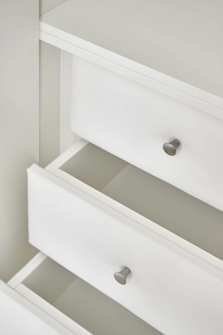 Arredamento su misura in legno bianco con cassetti scorrevoli e maniglie metalliche.