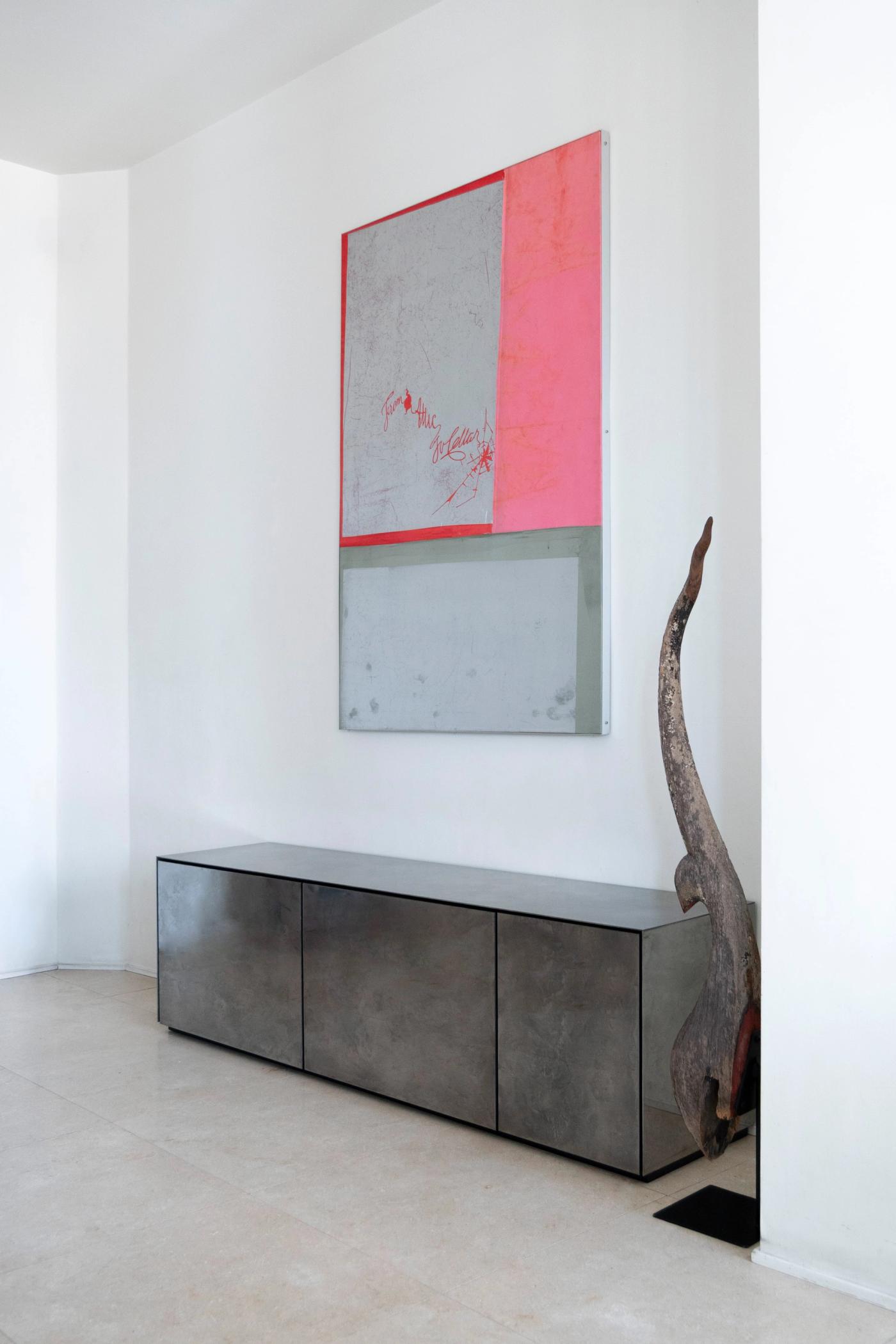 Arredamento su misura in cemento: credenza moderna con pannello lavagna rosa e cornice rossa.