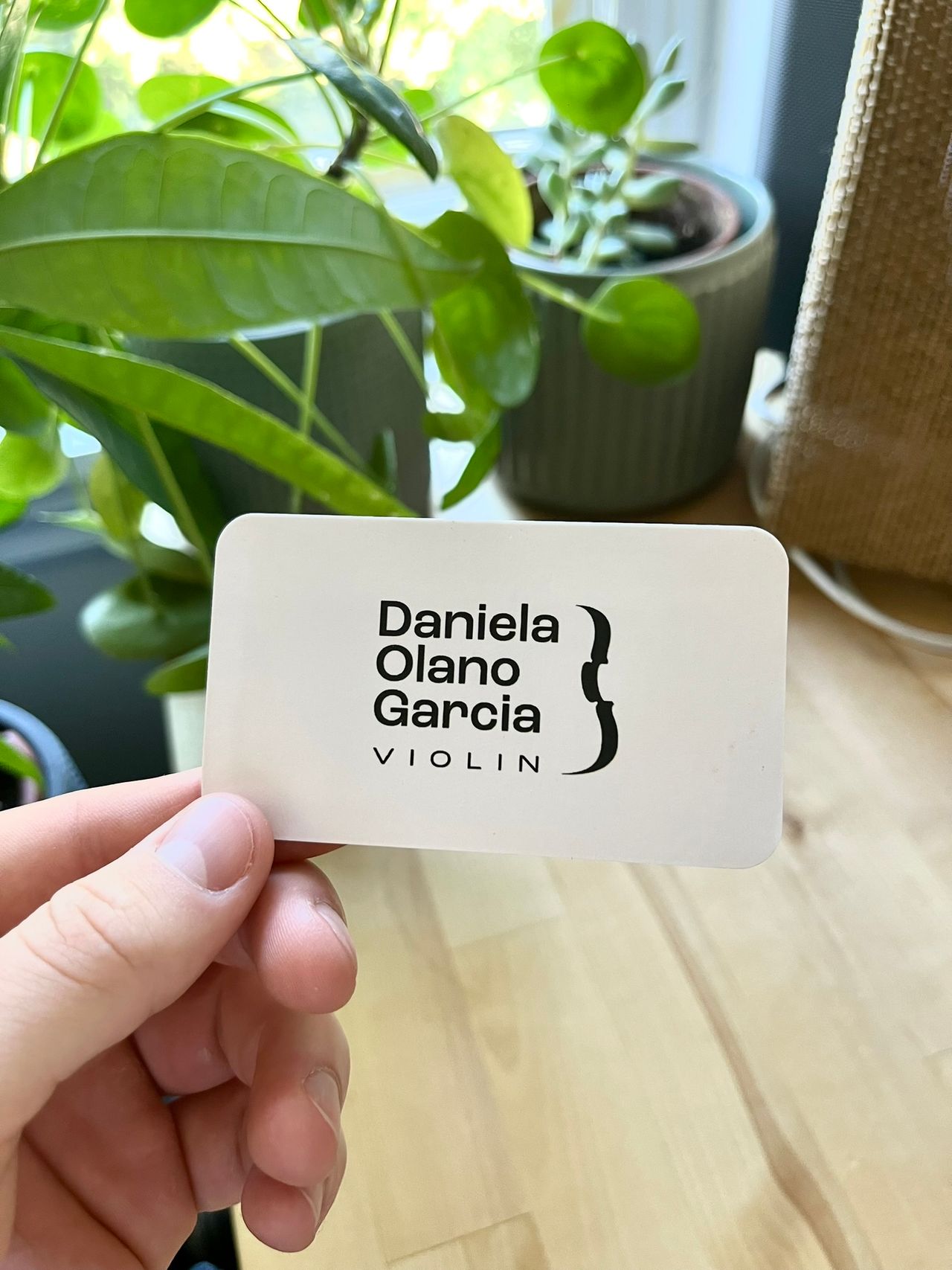 The back of Daniela's business card. Solid white with her logo in the middle.