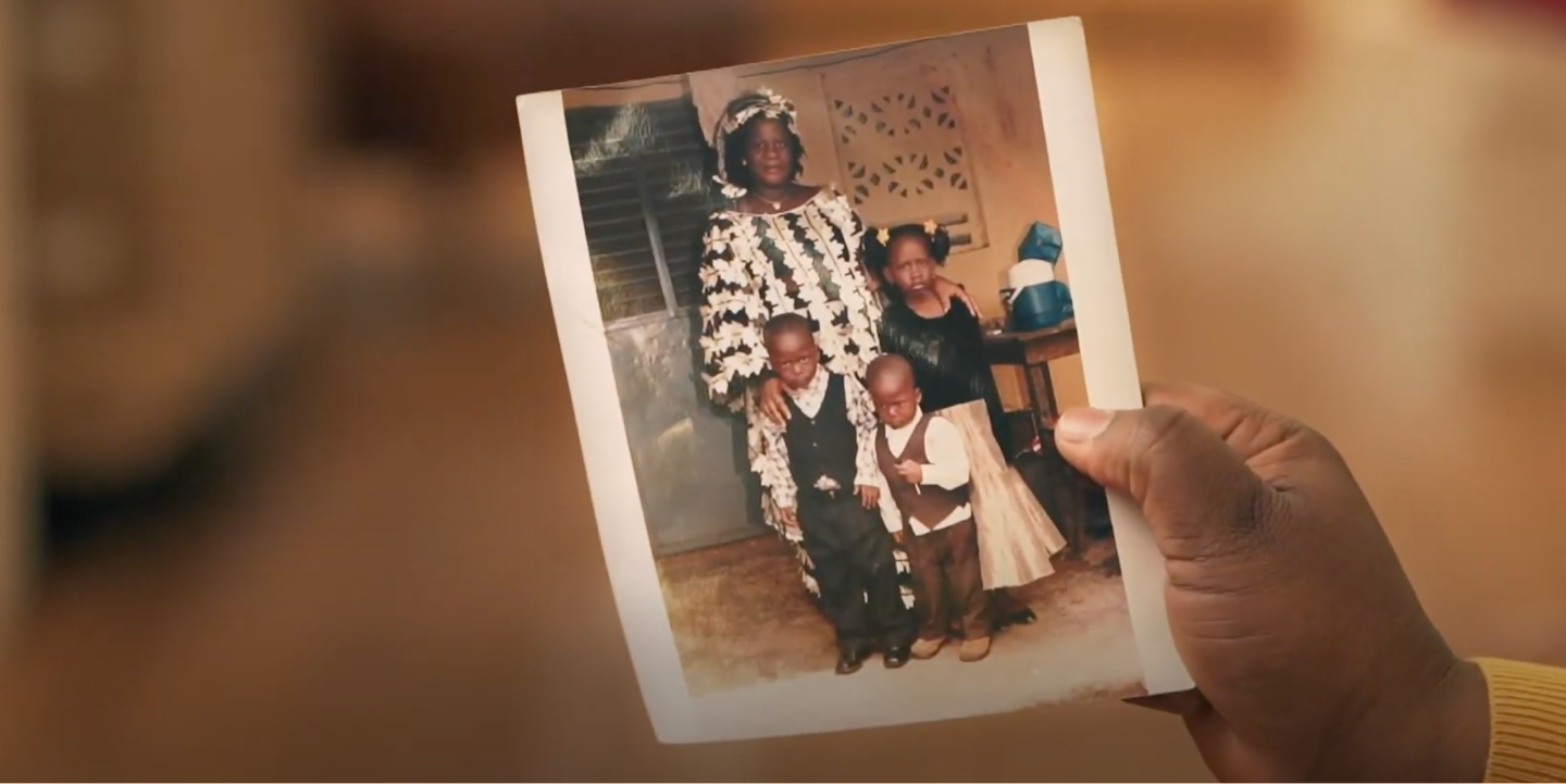 An faded photograph of a refugee family is held in hand