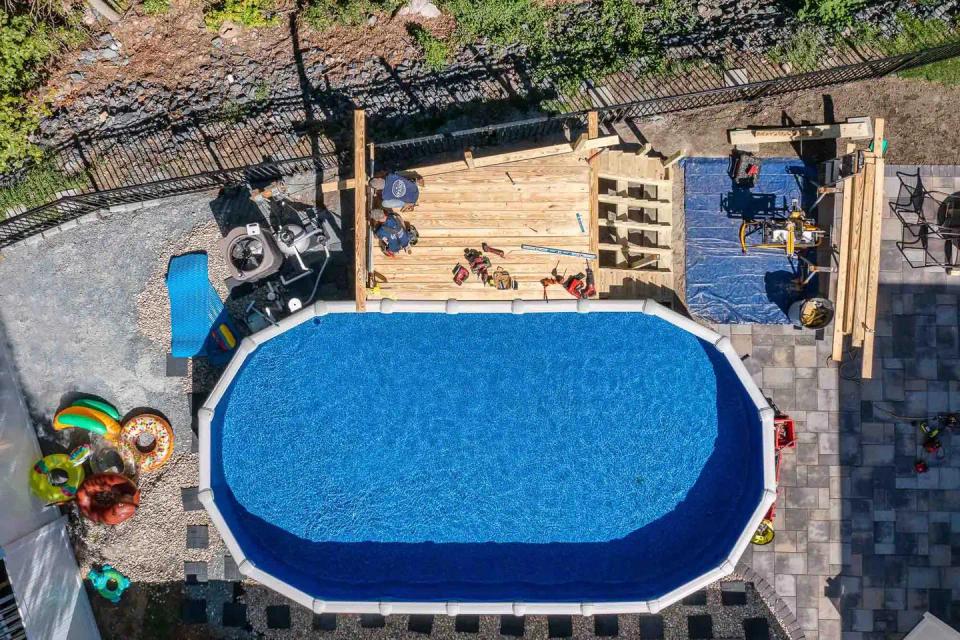 Top-down view of the above-ground pool, unfinished deck, stair framing and tools