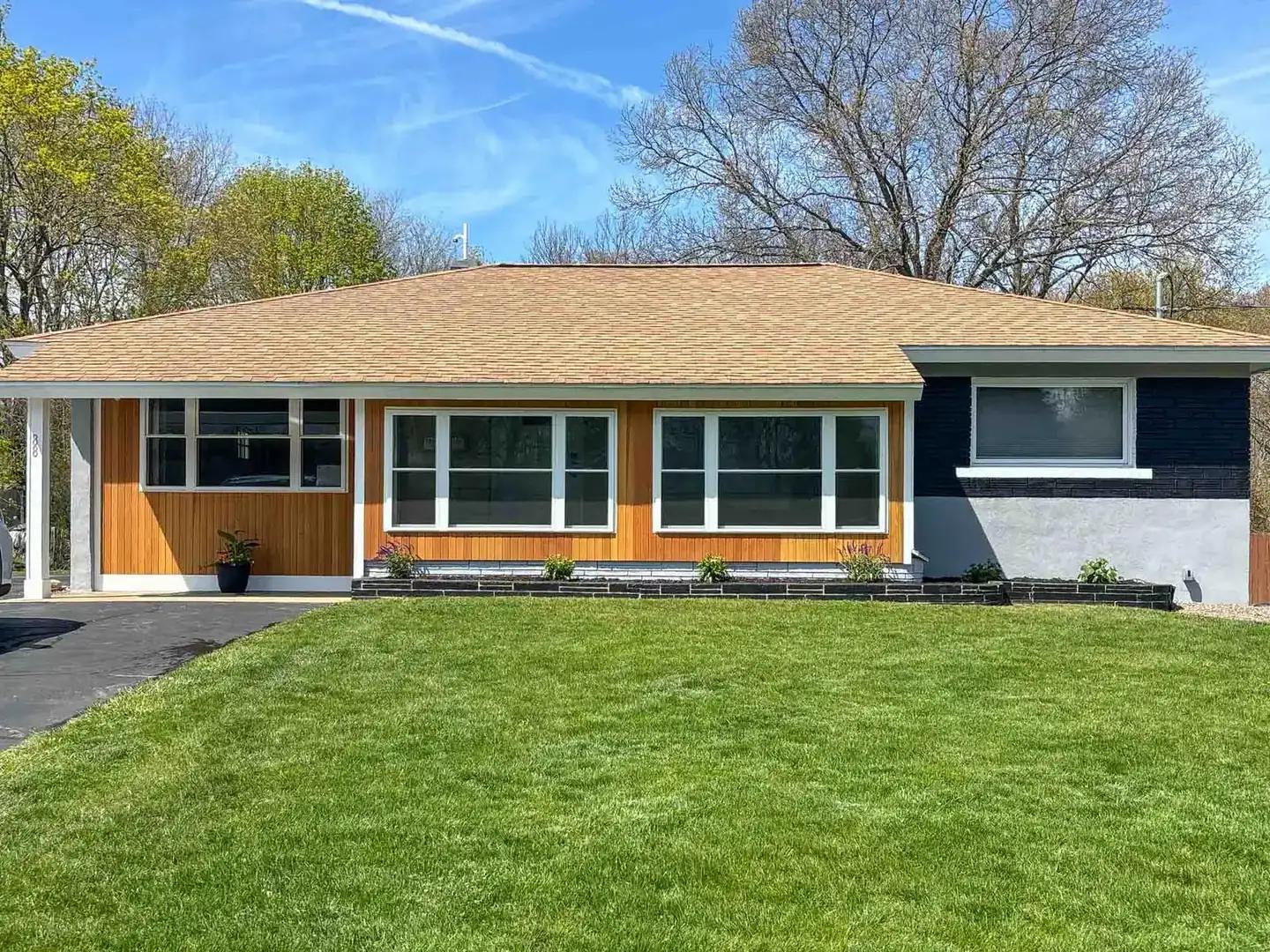 Cedar accent siding and white window trim on a renovated ranch in Raynham