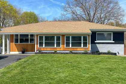 Cedar accent siding and white window trim on a renovated ranch in Raynham