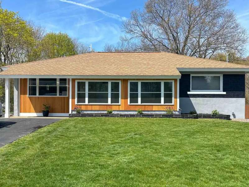 Cedar accent siding and white window trim on a renovated ranch in Raynham