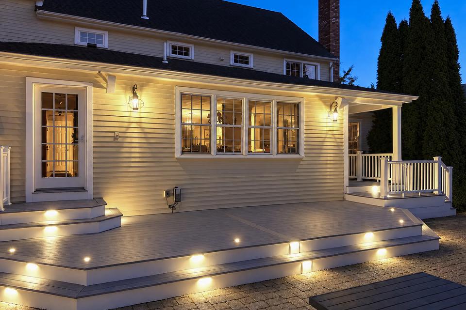Wide nighttime view of the deck with illuminated steps and deck lights