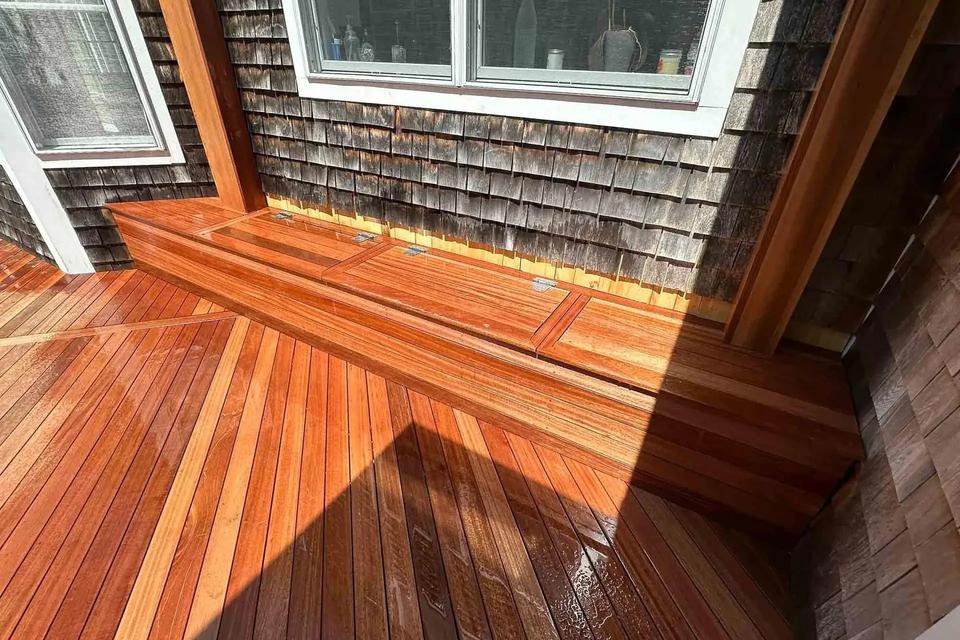 Close view of angled mahogany boards and a border meeting beside a shingled wall