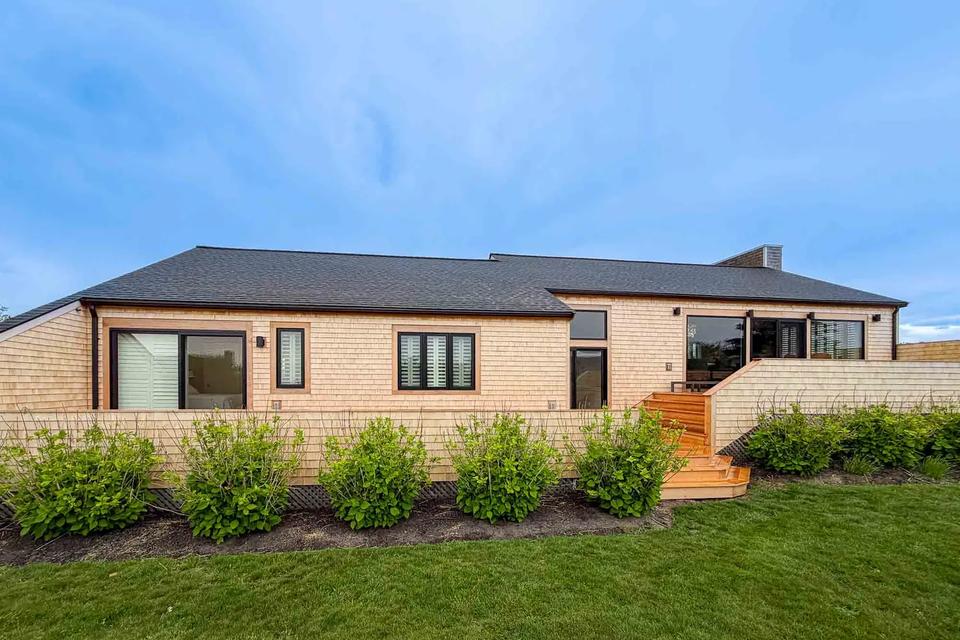 Cedar-shingled coastal home exterior with the new deck