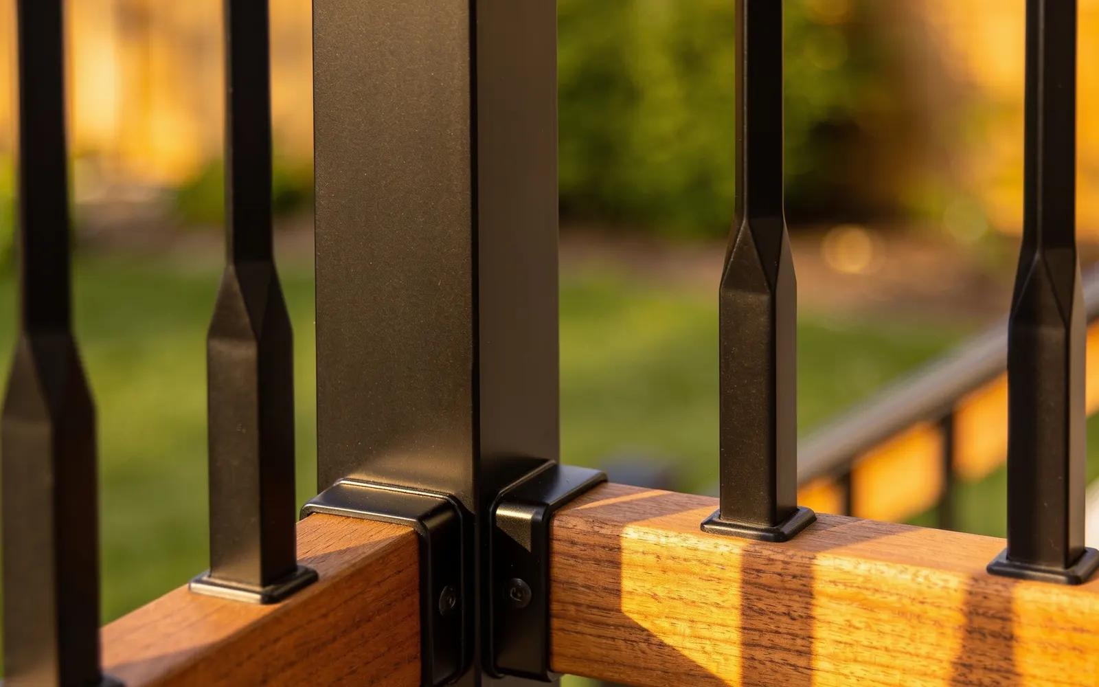 Modern deck railing with black aluminum balusters and a wood drink cap rail