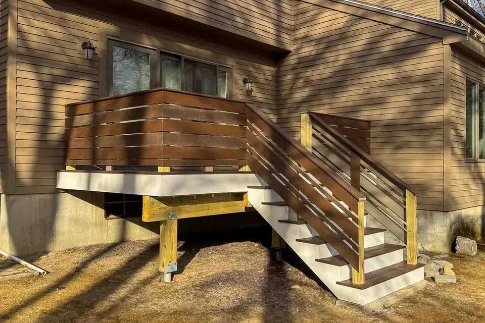 Raised deck and staircase viewed across the backyard toward the sliding glass door