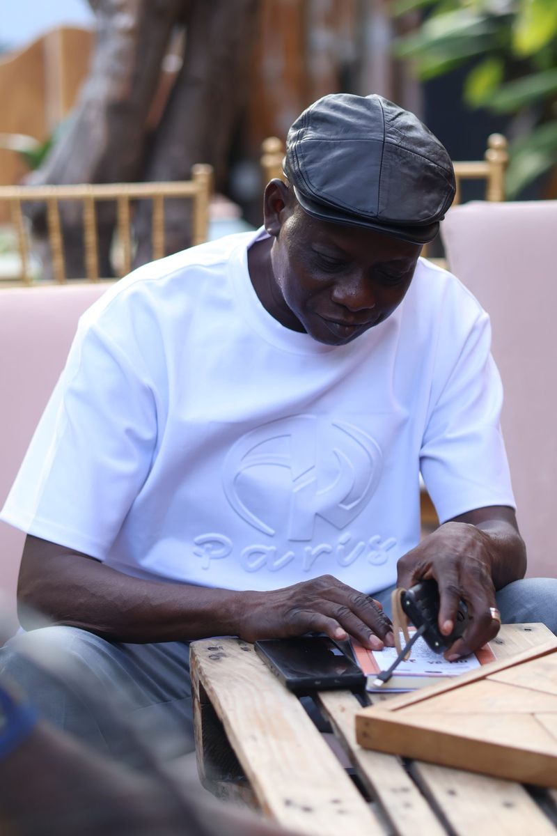 A man in a cap works with his hands on wooden boards while setting up the event