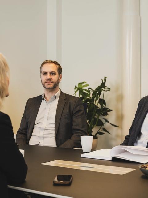 møte med tre smilende menesker.