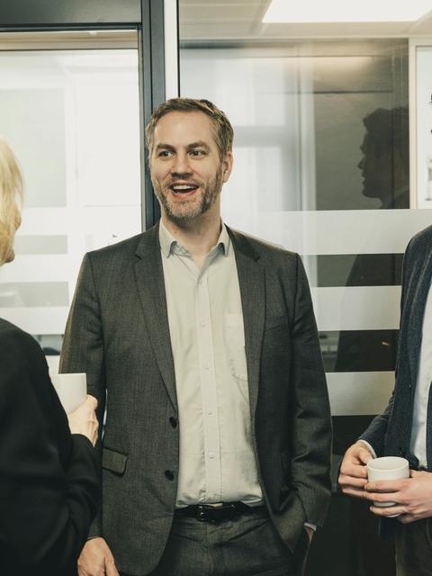 tre stykk snakker på et kontor.
