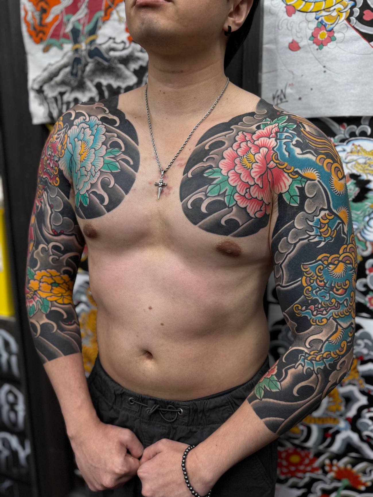 Kevin - Bold irezumi full sleeves and matching chest panels come together with classic peonies, wind bars, and a coiling dragon in full traditional colour.
