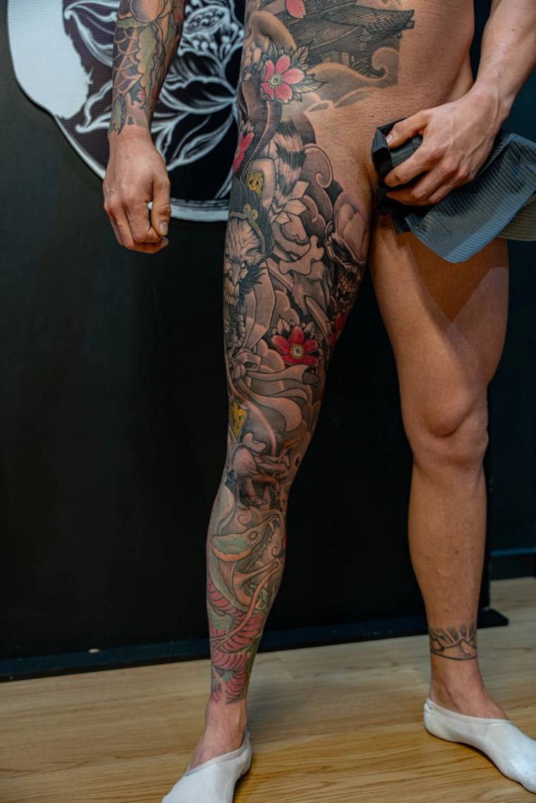 Finished Japanese irezumi full leg sleeve featuring a hannya mask, red chrysanthemums, snake, pagoda, and flowing clouds and 