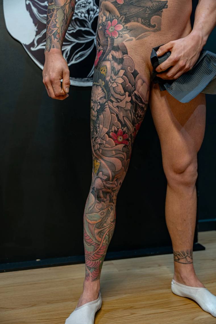 Finished irezumi full leg sleeve featuring a dragon, koi fish, snake, cherry blossoms, and a temple, rendered in vibrant colo