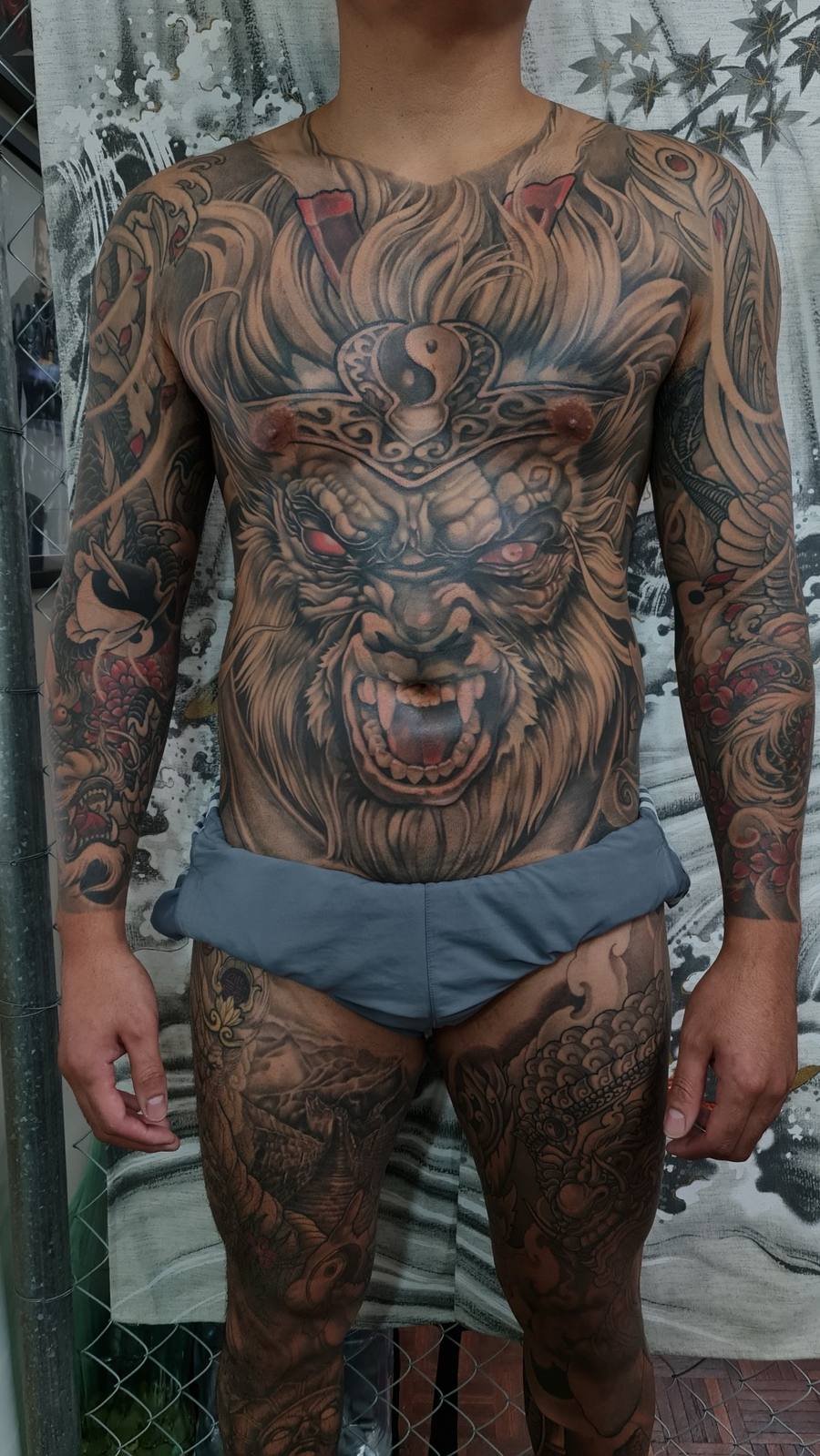 A bold full-back irezumi composition anchored by a fierce hannya mask, flowing into dragons, koi and waves across the arms and legs. by JVN