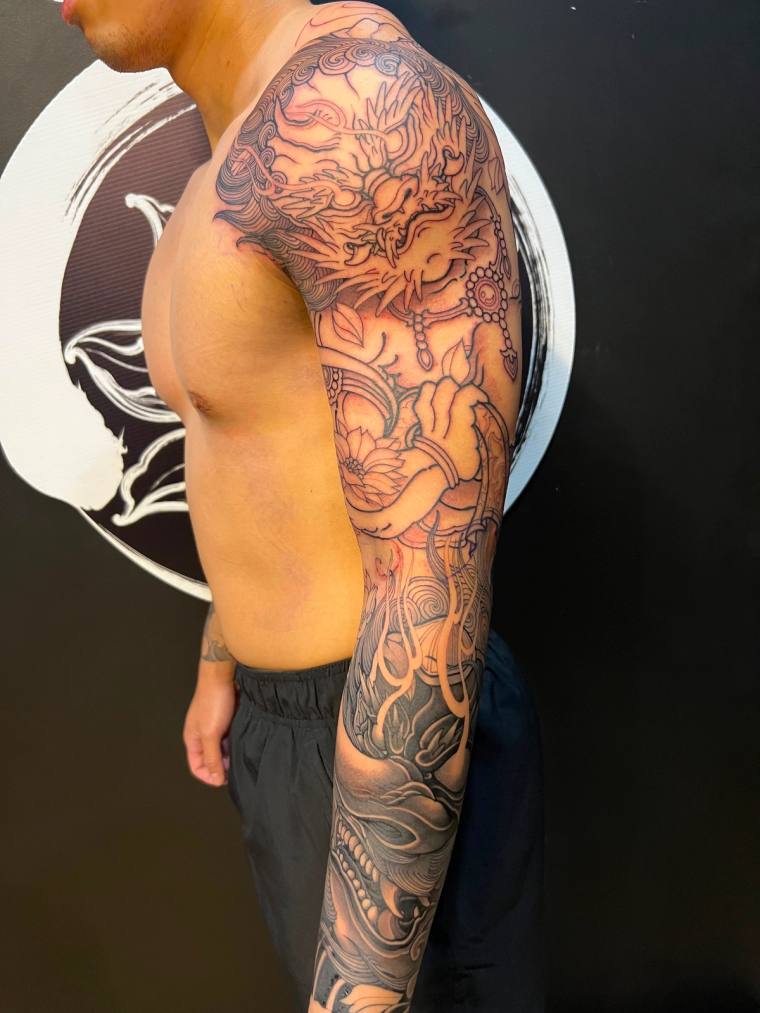In progress arm sleeve with a Japanese demon and a Tengu mask.