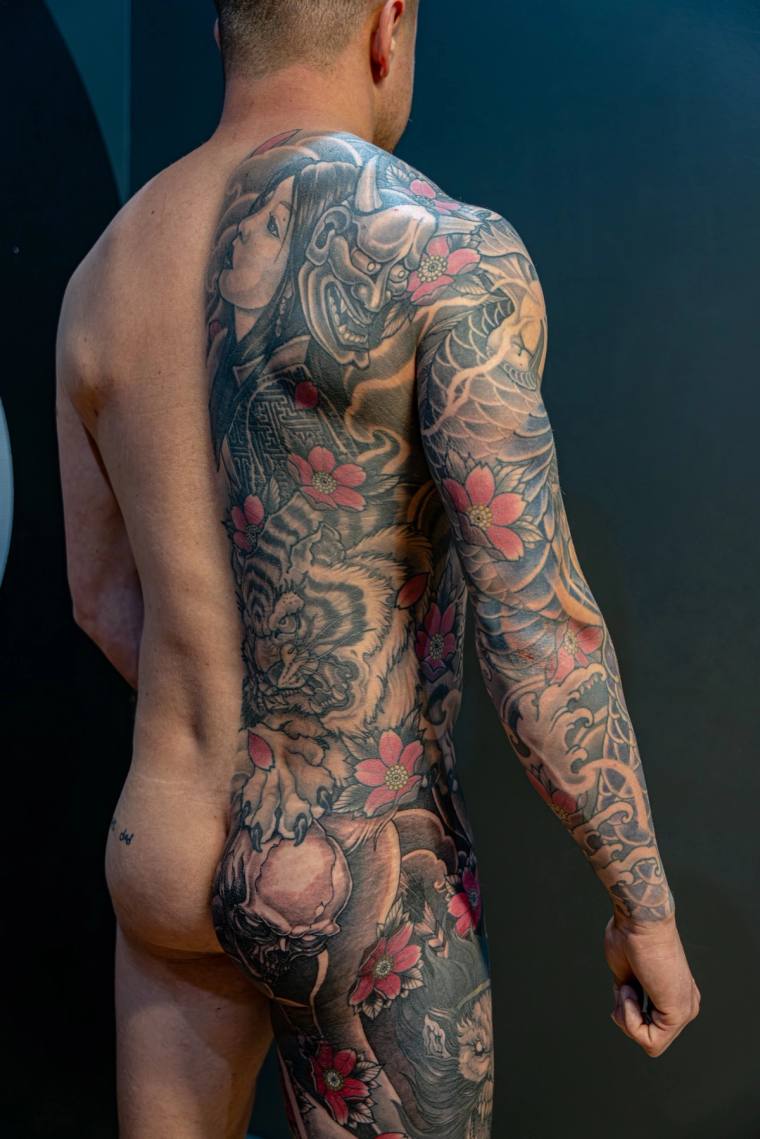 Finished irezumi back and full sleeve tattoo featuring a hannya mask, tiger, koi, and cherry blossoms in black, grey, and red