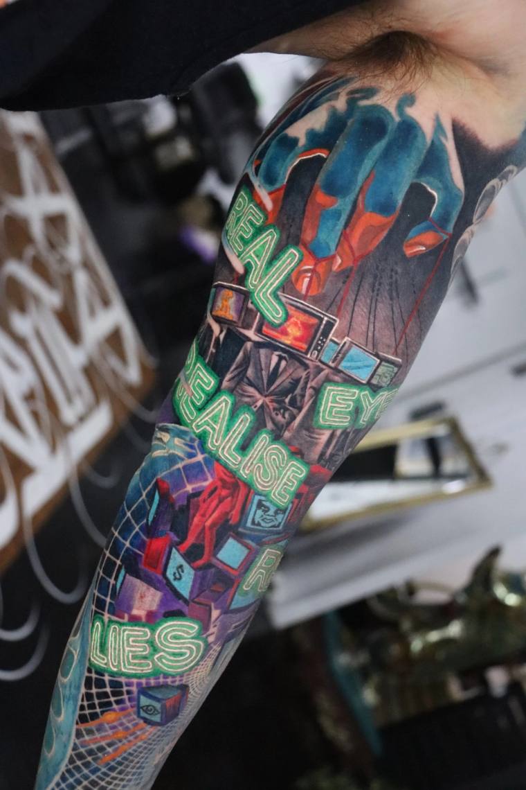 Vibrant neo-traditional forearm sleeve featuring neon green typography reading 'REALISE EYE LIES' amid geometric cubes, retro