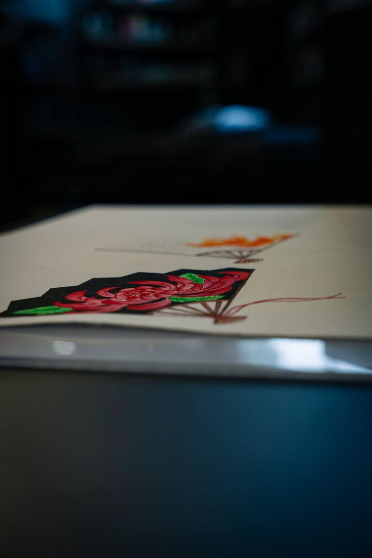 Chrysanthemum fan flash, close detail, red petals and jade leaves on black, fineline oriental work. by Mandy