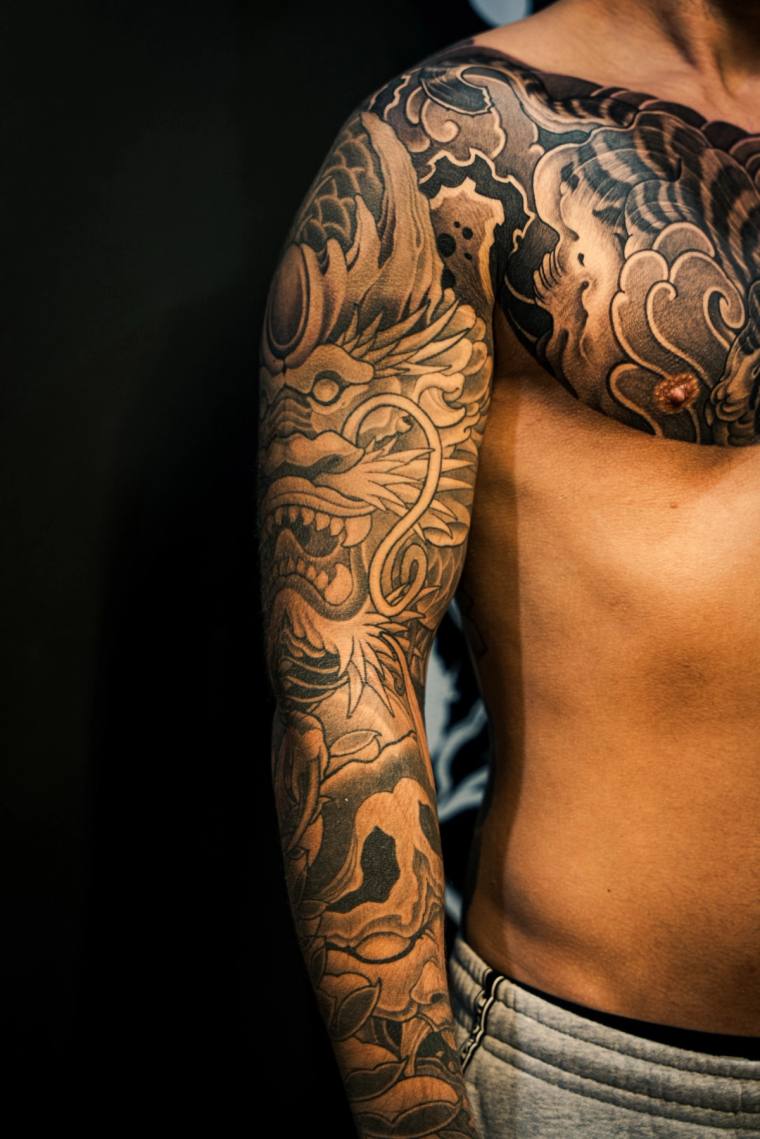 Finished irezumi full sleeve and chest piece featuring a fanged oni mask, koi fish, and traditional Japanese clouds and waves