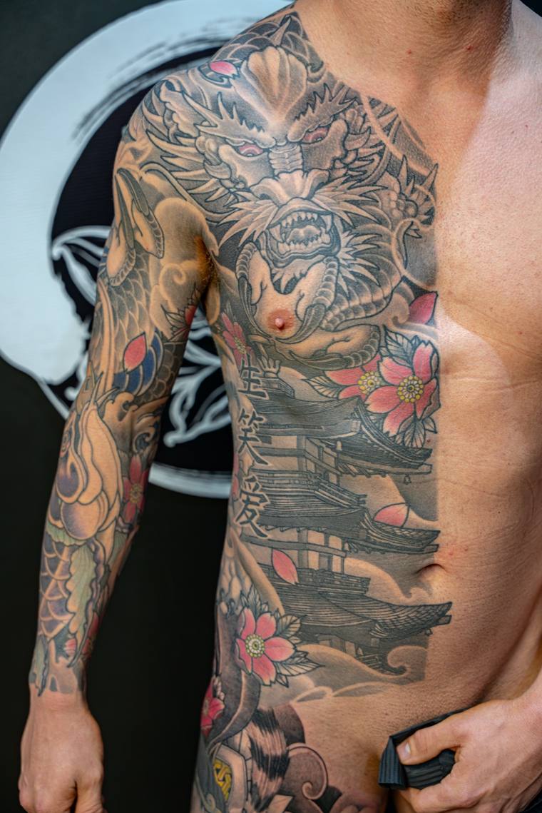 Finished irezumi sleeve and side panel featuring a snarling dragon, a tiered pagoda, koi fish, and pink cherry blossoms on a 