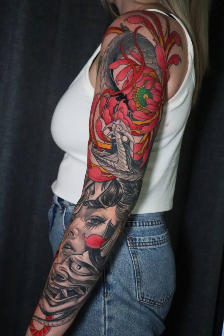 Finished irezumi full sleeve featuring a hannya mask, geisha face, red spider chrysanthemum, snake, and green folding fan on 