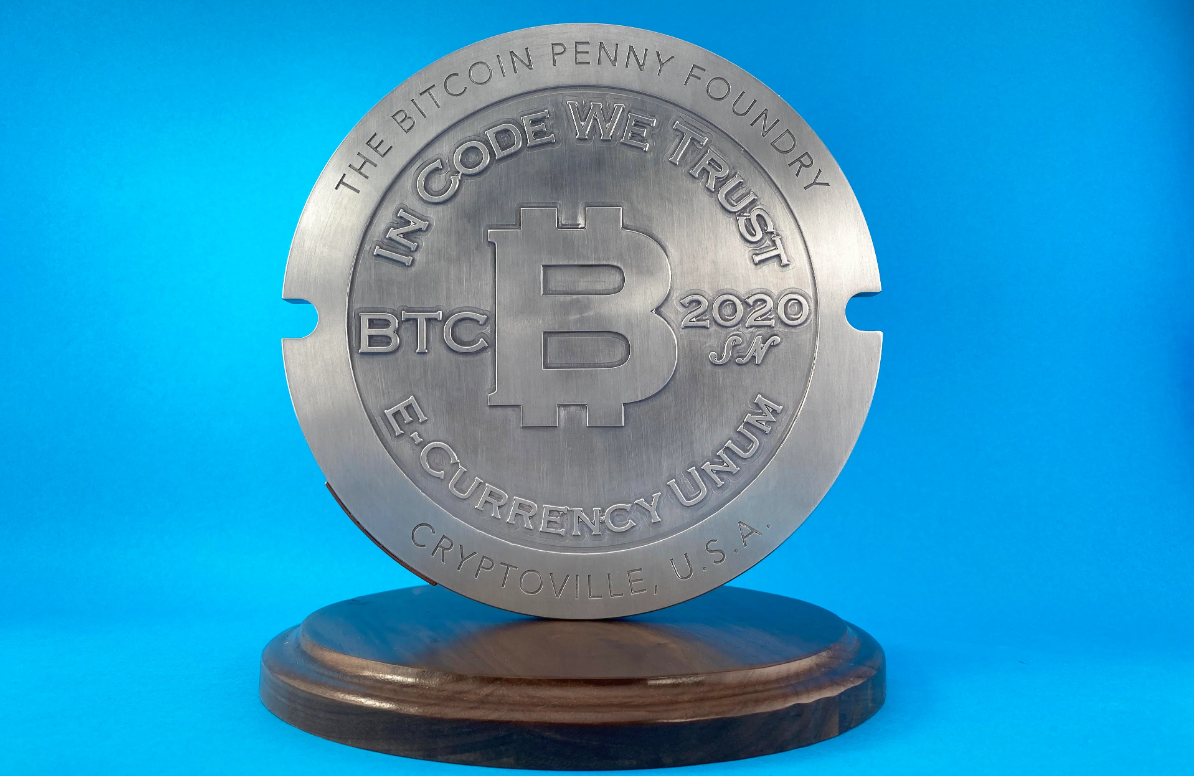 Mini Bitcoin Penny Manhole Cover displayed on the ground, roughly the size of a dinner plate - Flush